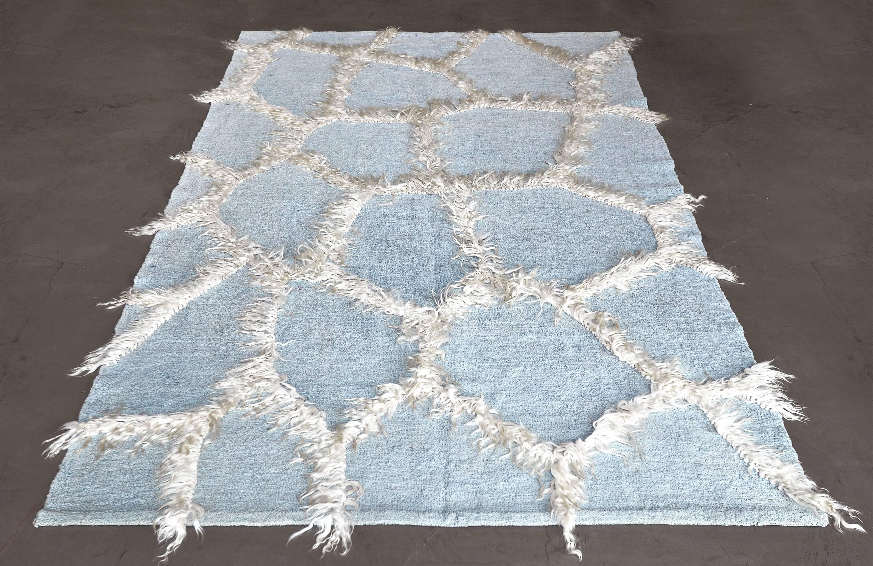 Dieser handgewebte türkische Teppich aus den 70er Jahren hat ein schattiertes himmelblaues Feld mit einem Gesamtmuster aus unregelmäßigen Polygonen, die von langen natürlichen Wollbüscheln gebildet werden.