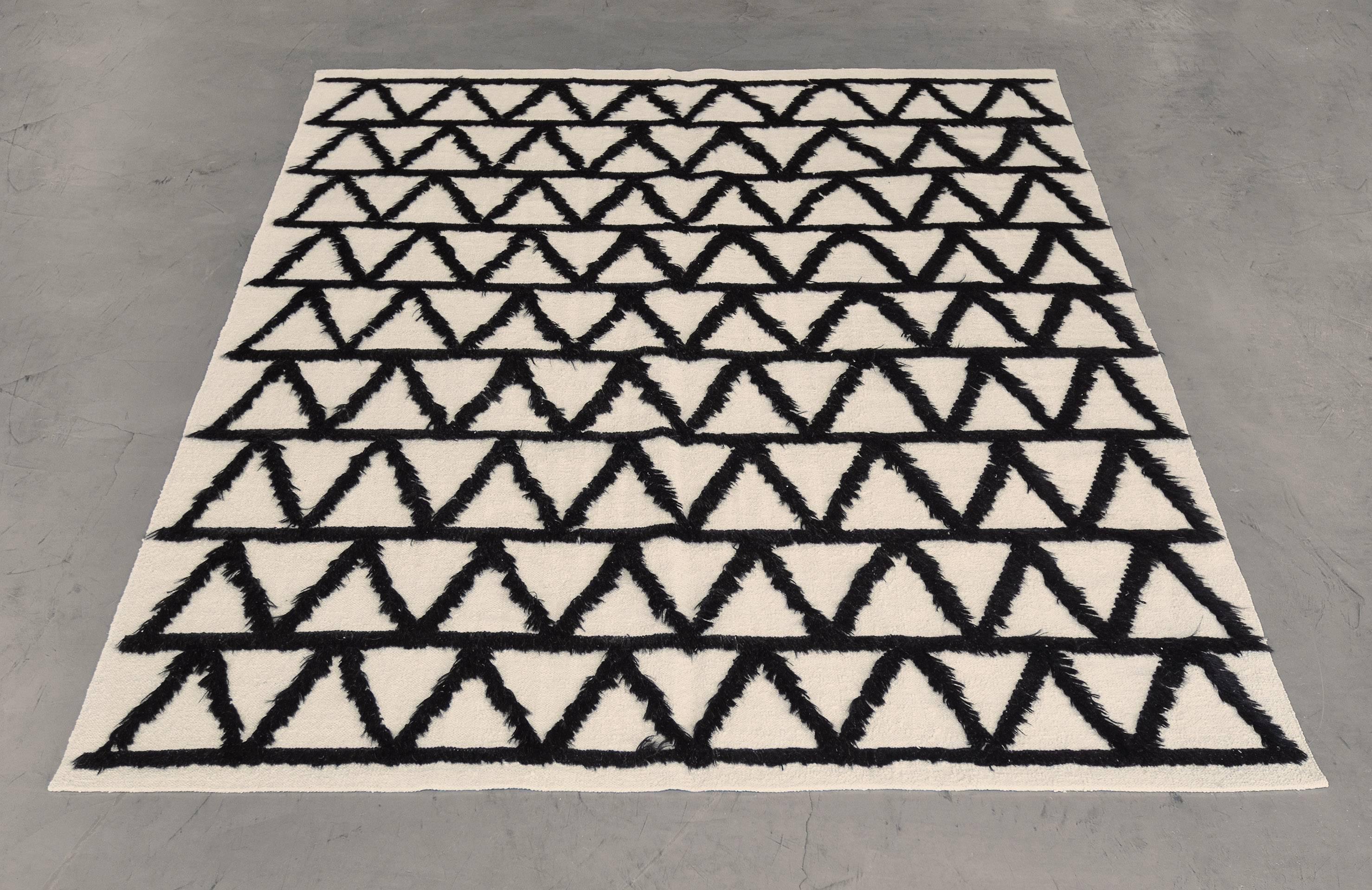 This vintage Turkish rug from the 70s has an ivory field with nine horizontal bands of bold chocolate-brown zig-zag motifs formed by goat hair with a similar plain horizontal stripe above and below.