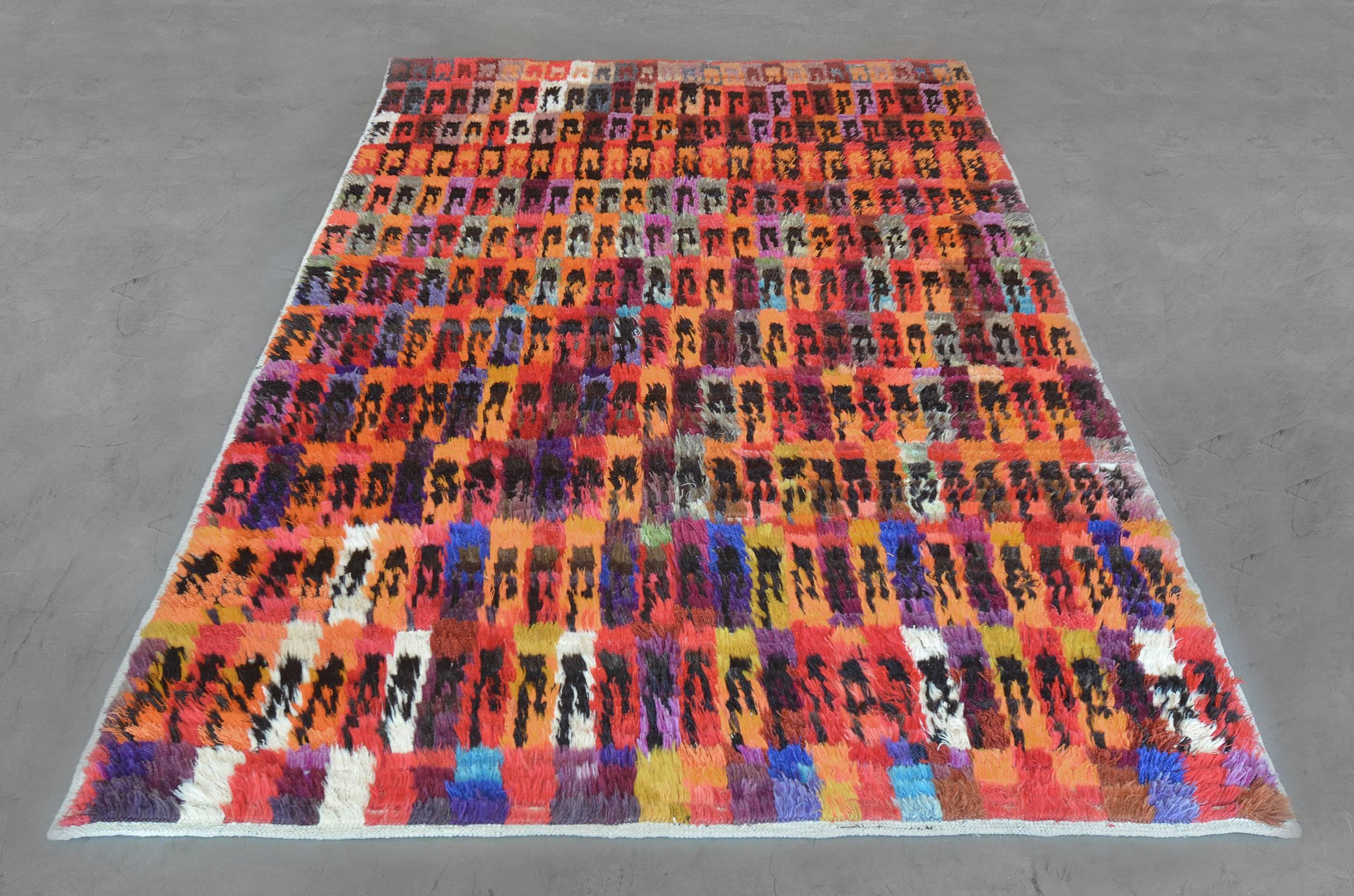 This hand knotted, high pile colorful Turkish wool rug from the late 20th century has a striking, prismatic design. Its intriguing colors and rhythmic pattern gives the 6’4”x 8’10” rug a sense of vibrancy and liveliness.