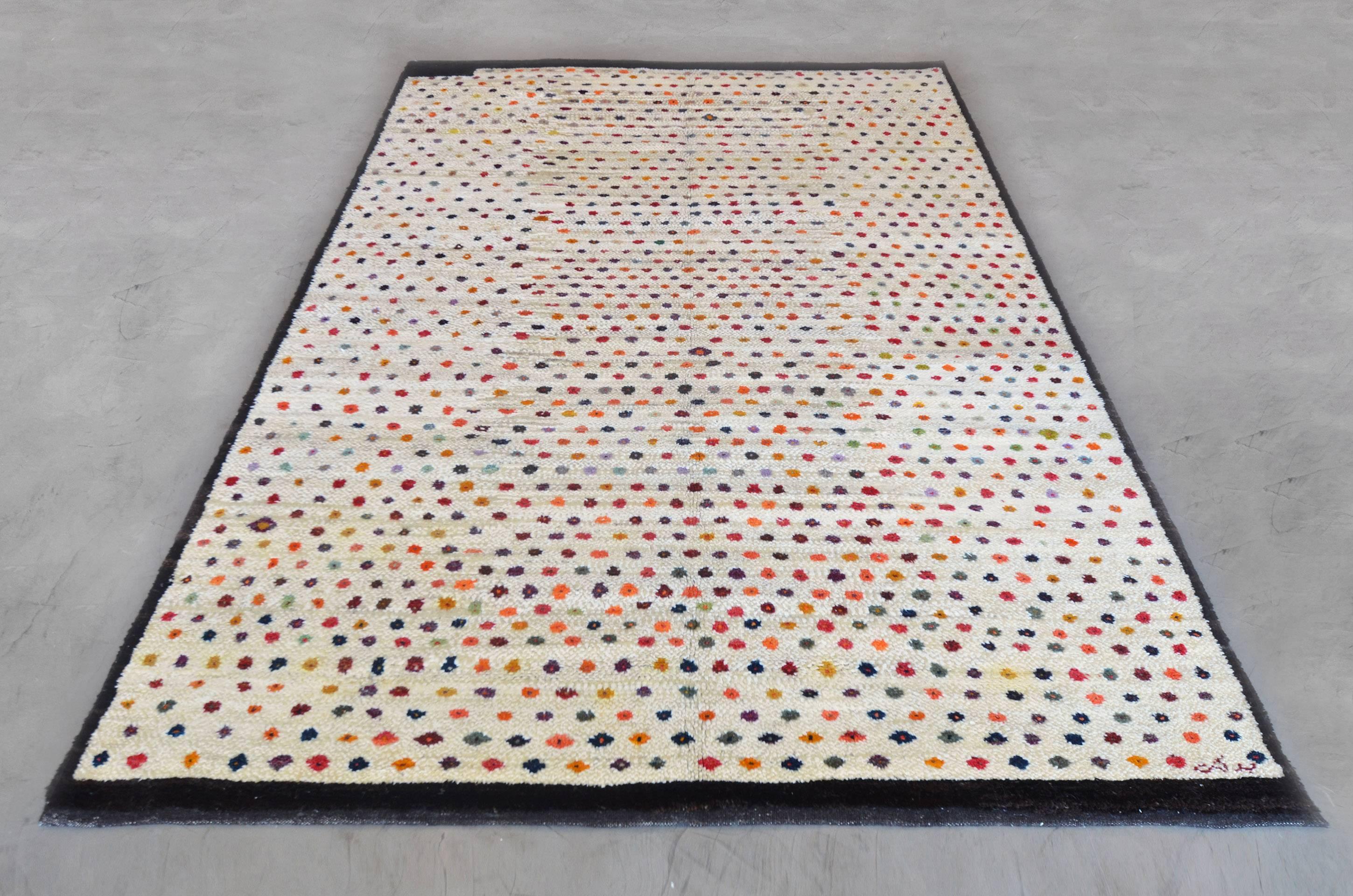 A one of a kind, hand-knotted Turkish wool and soft hemp rug from the 70s. This 6’7” x 9’ rug’s whimsical design is created by polychromatic dots scattered across a neutral beige field - framed by a strong border. The nature of this rug adds a