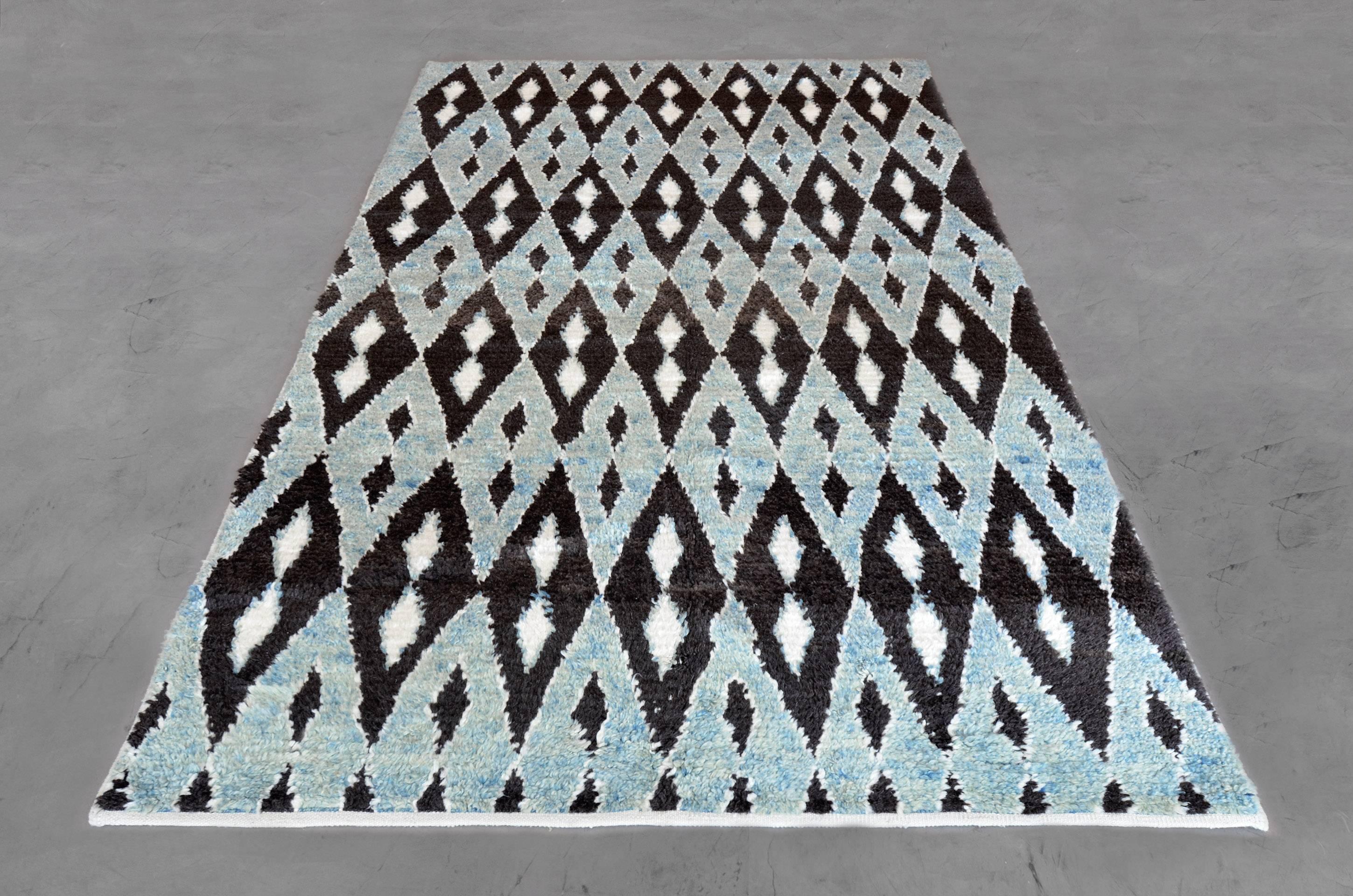 This deco-inspired rug gives a youthful and whimsical feel with its geometric design scheme. This hand-knotted Turkish rug has a neutral color composition with an all-over repeated diamond pattern. Sized at 5’10” x 9’3” this piece adds character and