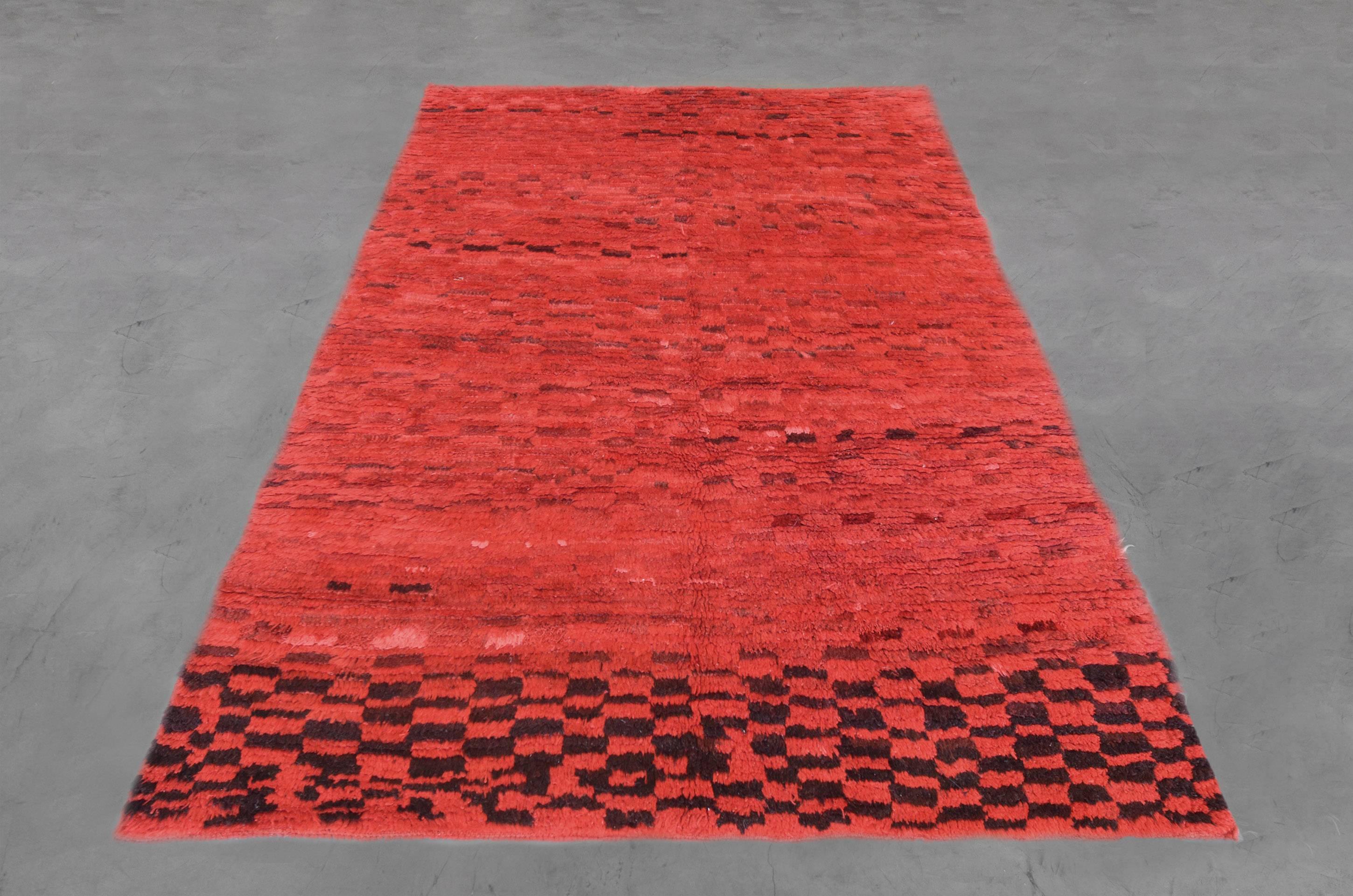 This one of a kind vintage Moroccan rug has an intricately hand-knotted checkerboard pattern in deep maroon on a rich red field. Intermixed within the design of this late 20th century rug are beautifully braided details. Sized at 5’8” x 8’3” the