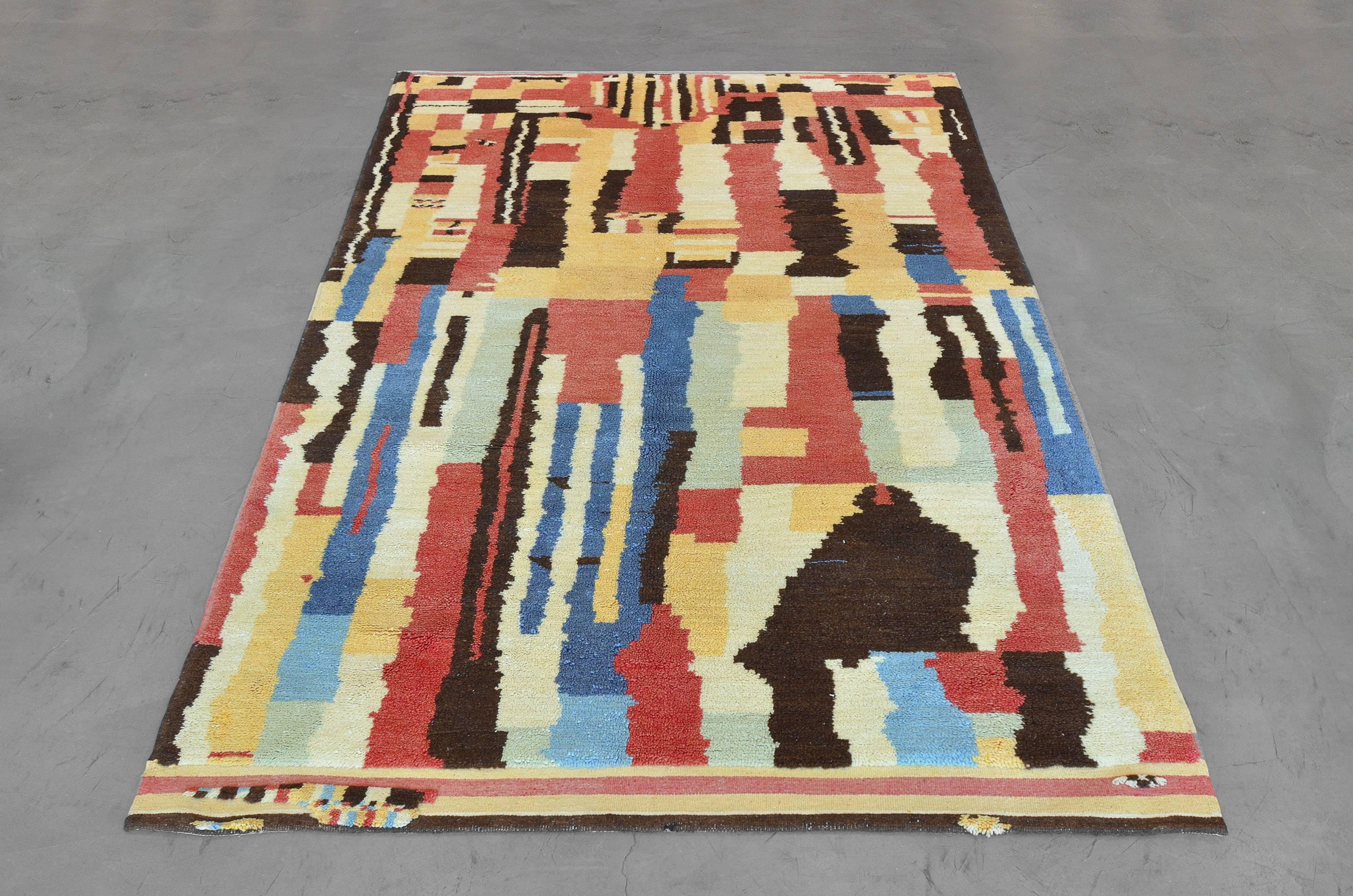 Late 20th century, hand-knotted wool rug from Morocco features an expressive collage of rectilinear color blocks and well-blended irregular segments in a vivid combination of red, citron, beige, black, and blues. Sized at 6’10” x 9’9” this vintage
