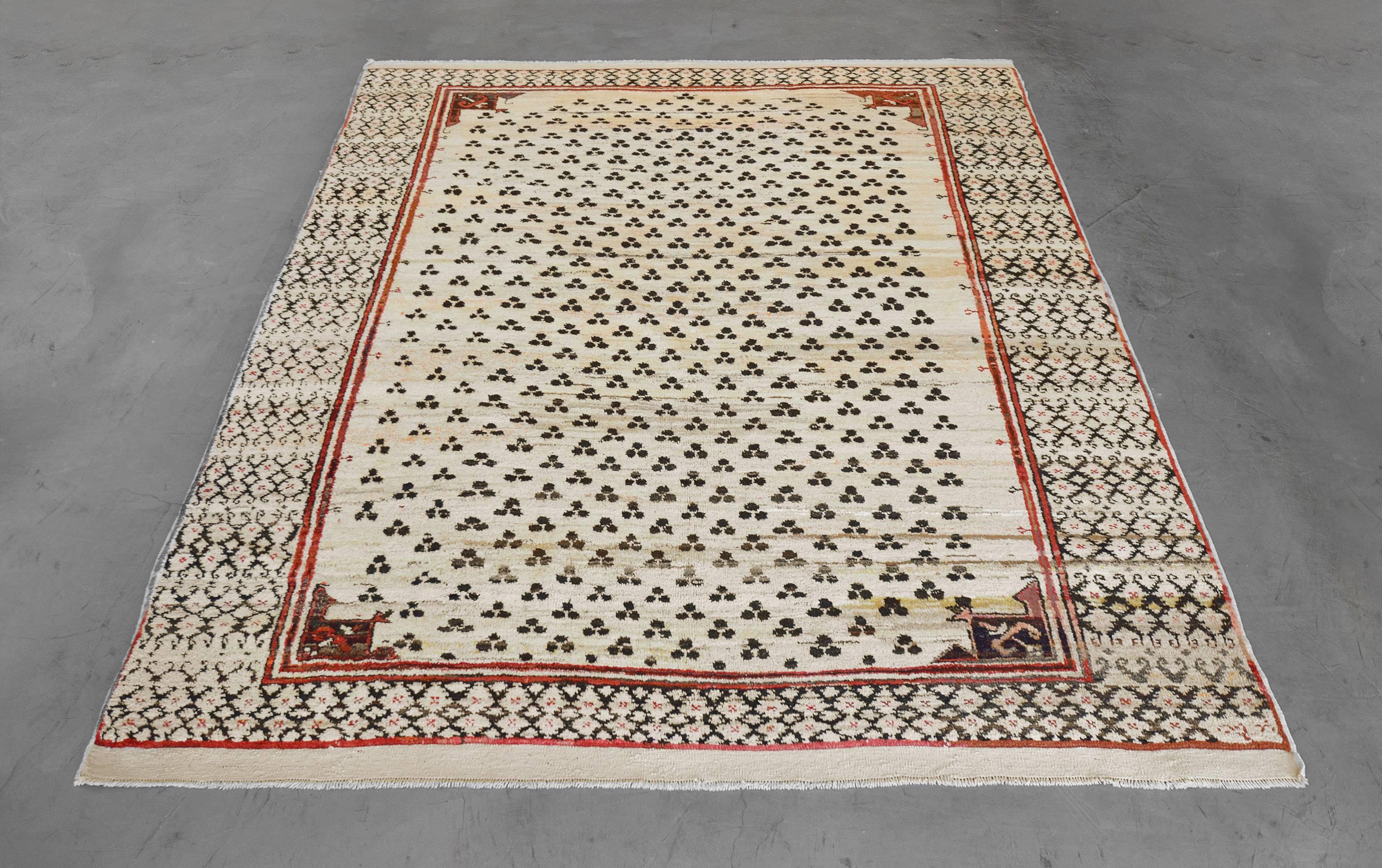 This dynamic vintage rug from the late 20th century is hand-knotted in Turkey from the finest wool. Sized at 7’3” x 8’7” this rug has a distinct tiger eye design on a muted beige field surrounded by a diamond pattern motif. The geometric pattern and