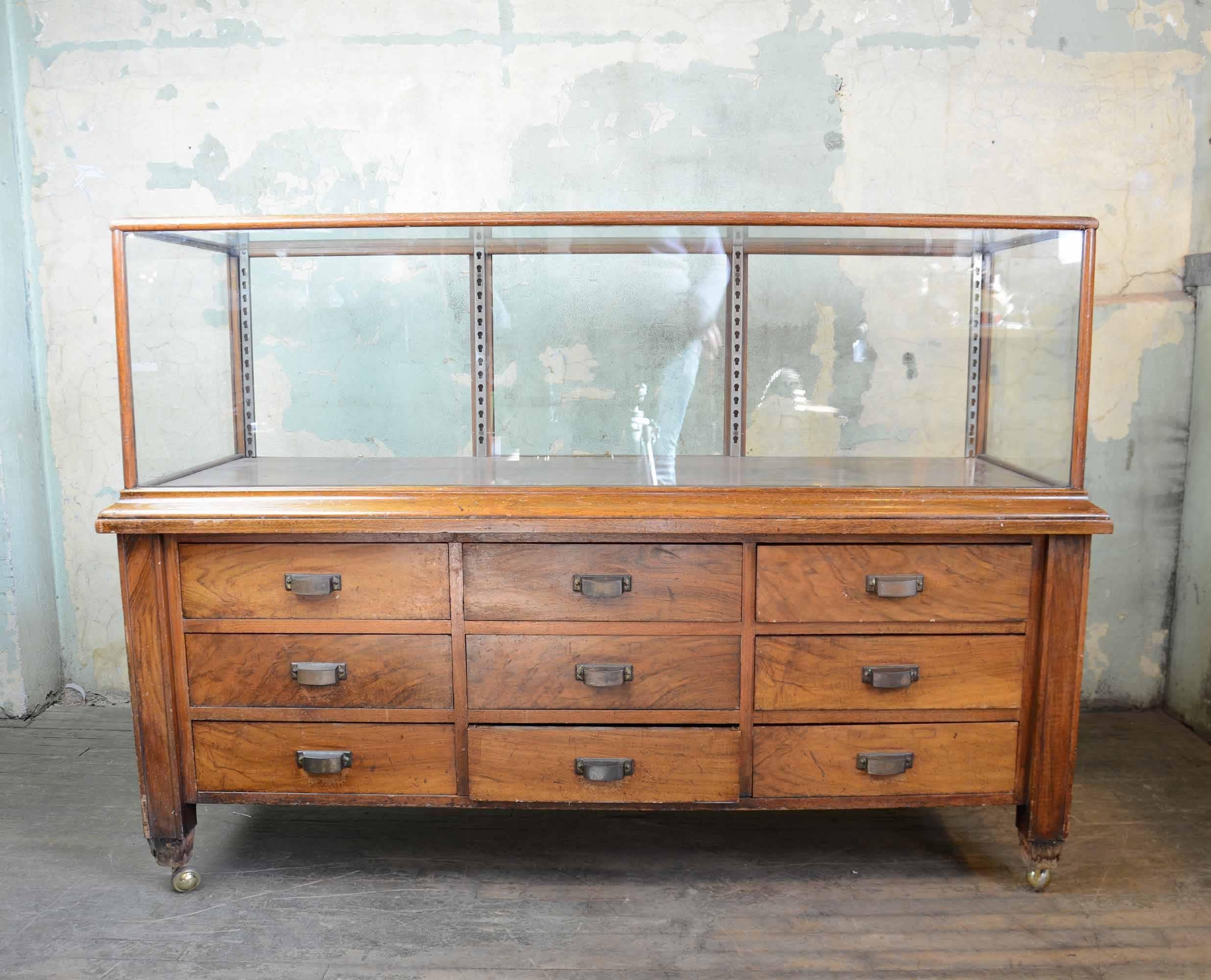 Beautiful wood display case with drawers. Features nine velvet lined drawers with cast brass hardware.