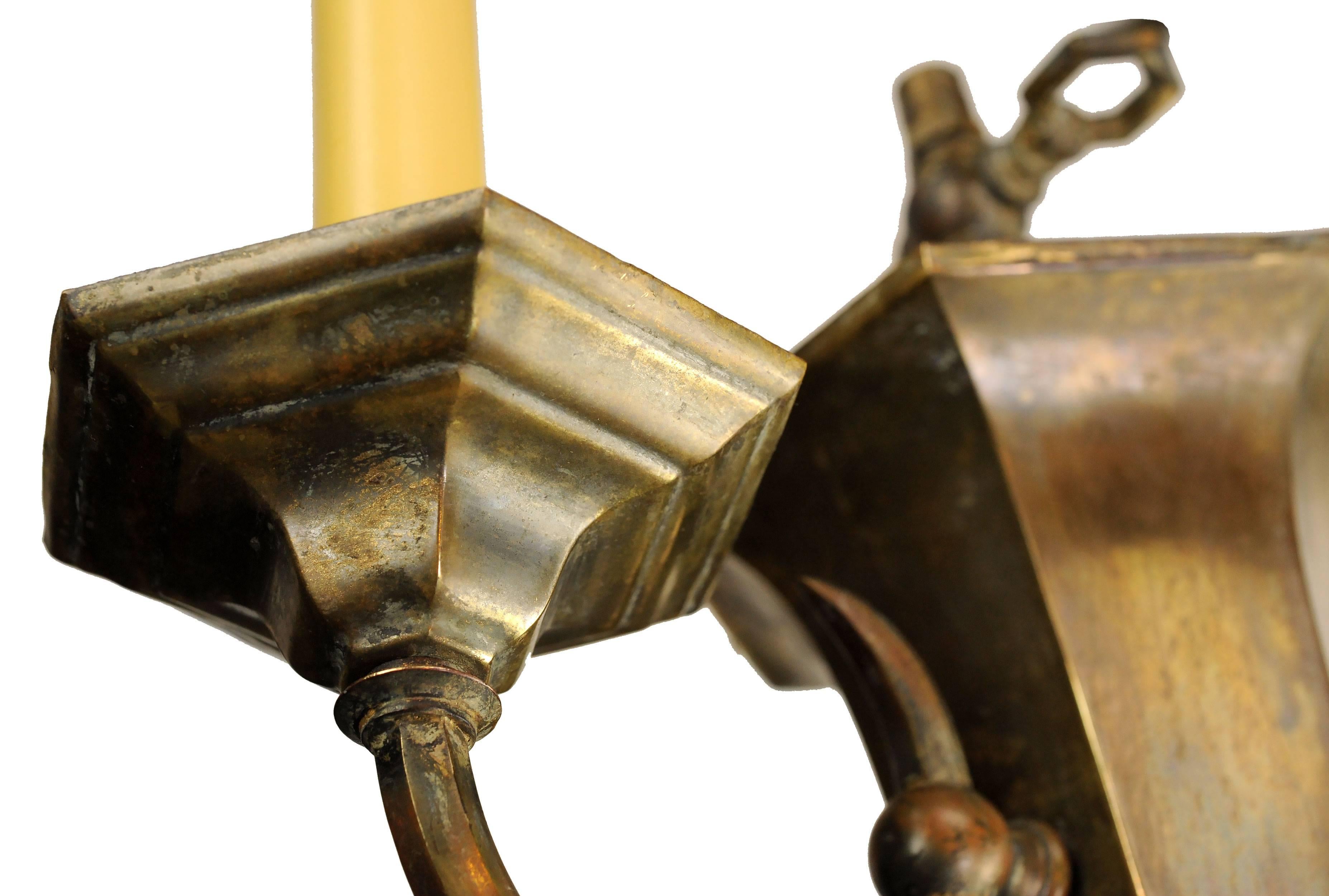 Stunning brass two candle gas/electric sconce with beautiful, mottled patina. Refined and elegant, these sconces will make a statement in any setting. 

Finish: Original
Two candelabra sockets

We find that early antique lighting was designed