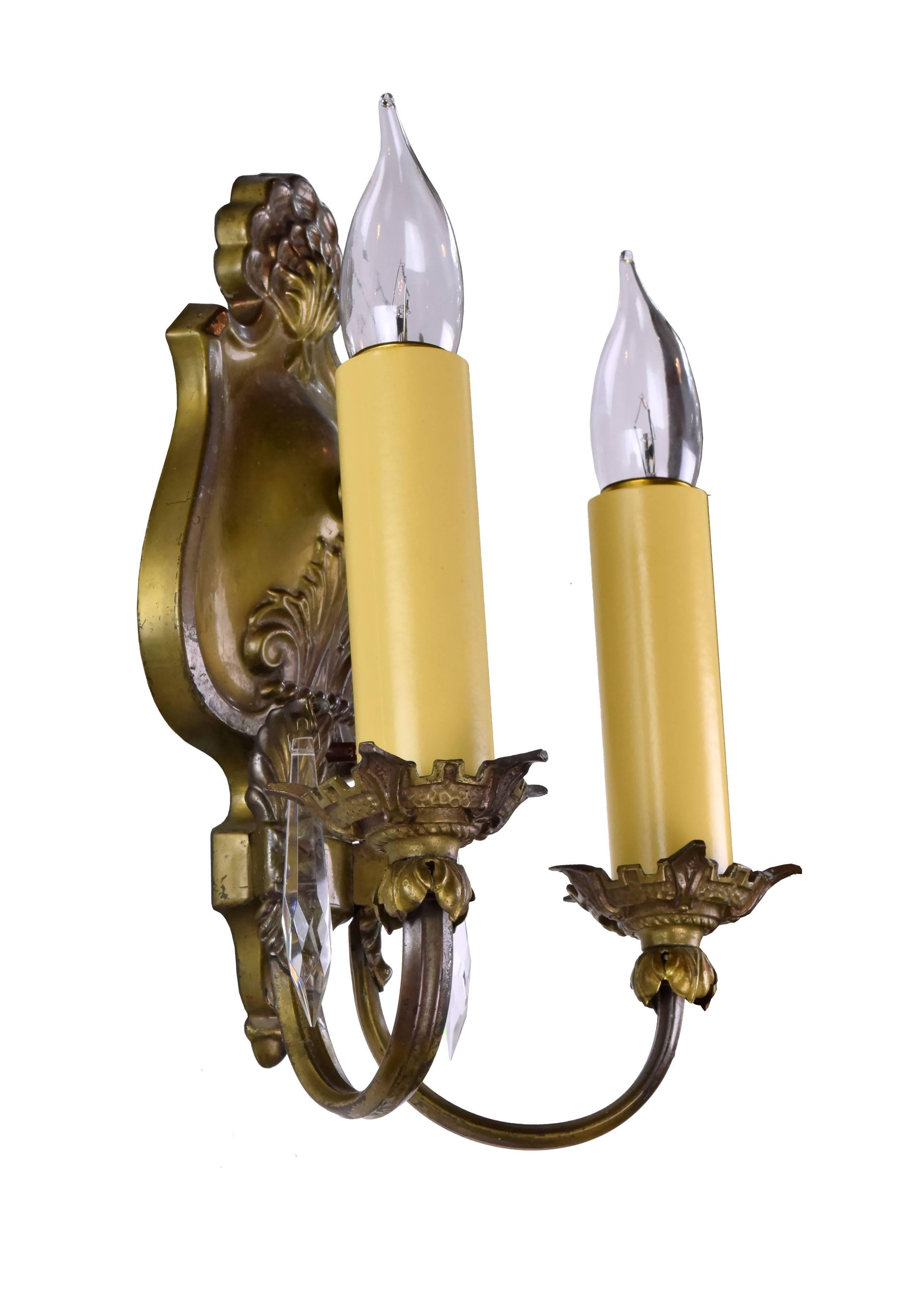 This elegant two-armed brass sconce features lavish organic details throughout, typical of the Beaux Arts movement. The pair of pointed crystals add another sumptuous touch to this beautiful fixture.


We find that early antique lighting was