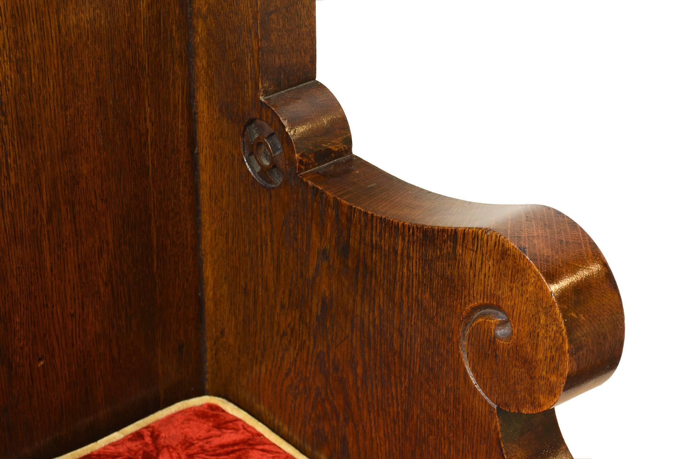 Ornate Gothic style, oak bishop's chair with trefoil designs. Includes red seat cushion and ample carved details.