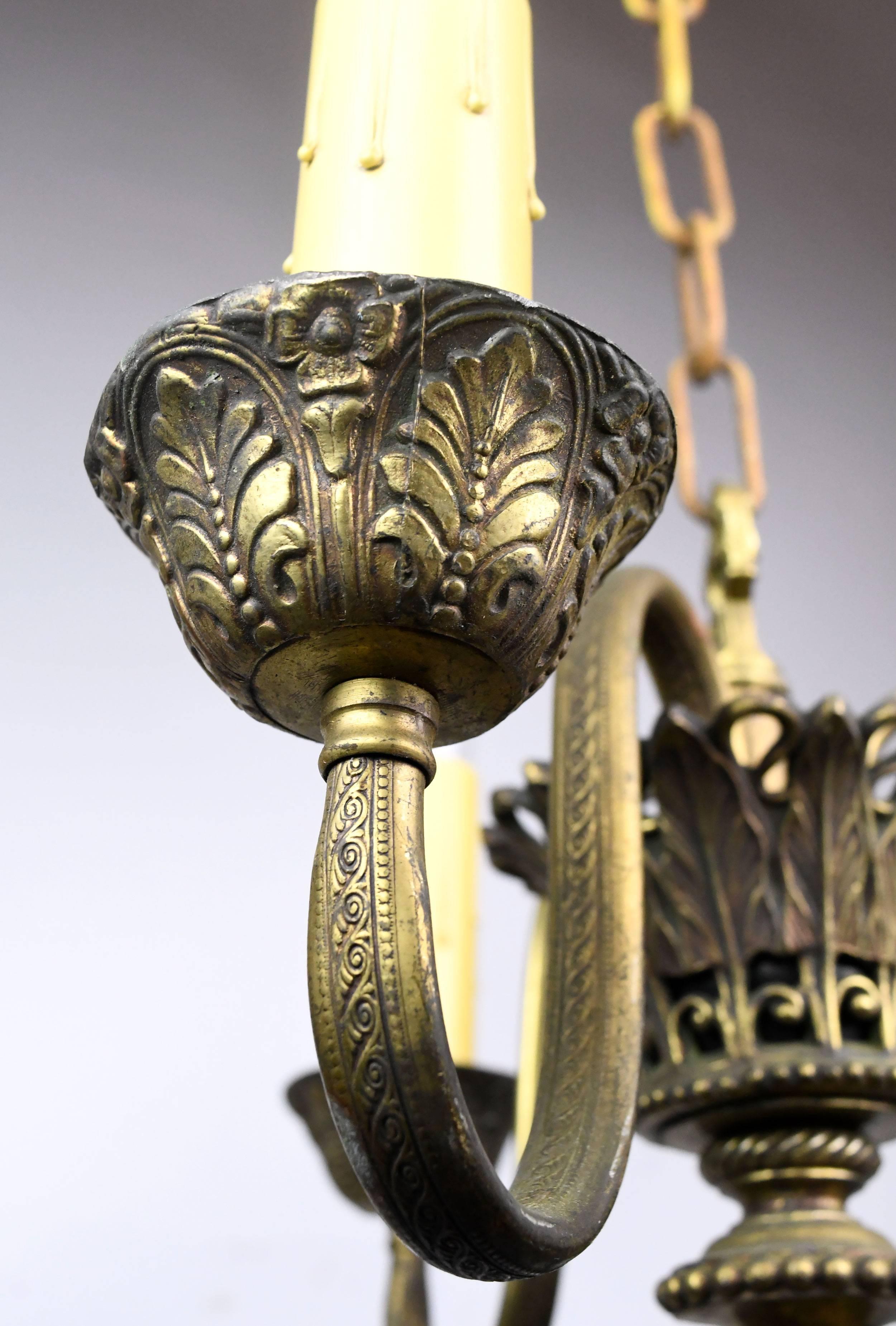 This gorgeous three-candle chandelier is composed of a mixture of cast brass and lead, giving the fixture considerable heft for its size. Sweeping arms are decorated with intricate patterns on top and bottom, and an ornate, oversized finial adds a