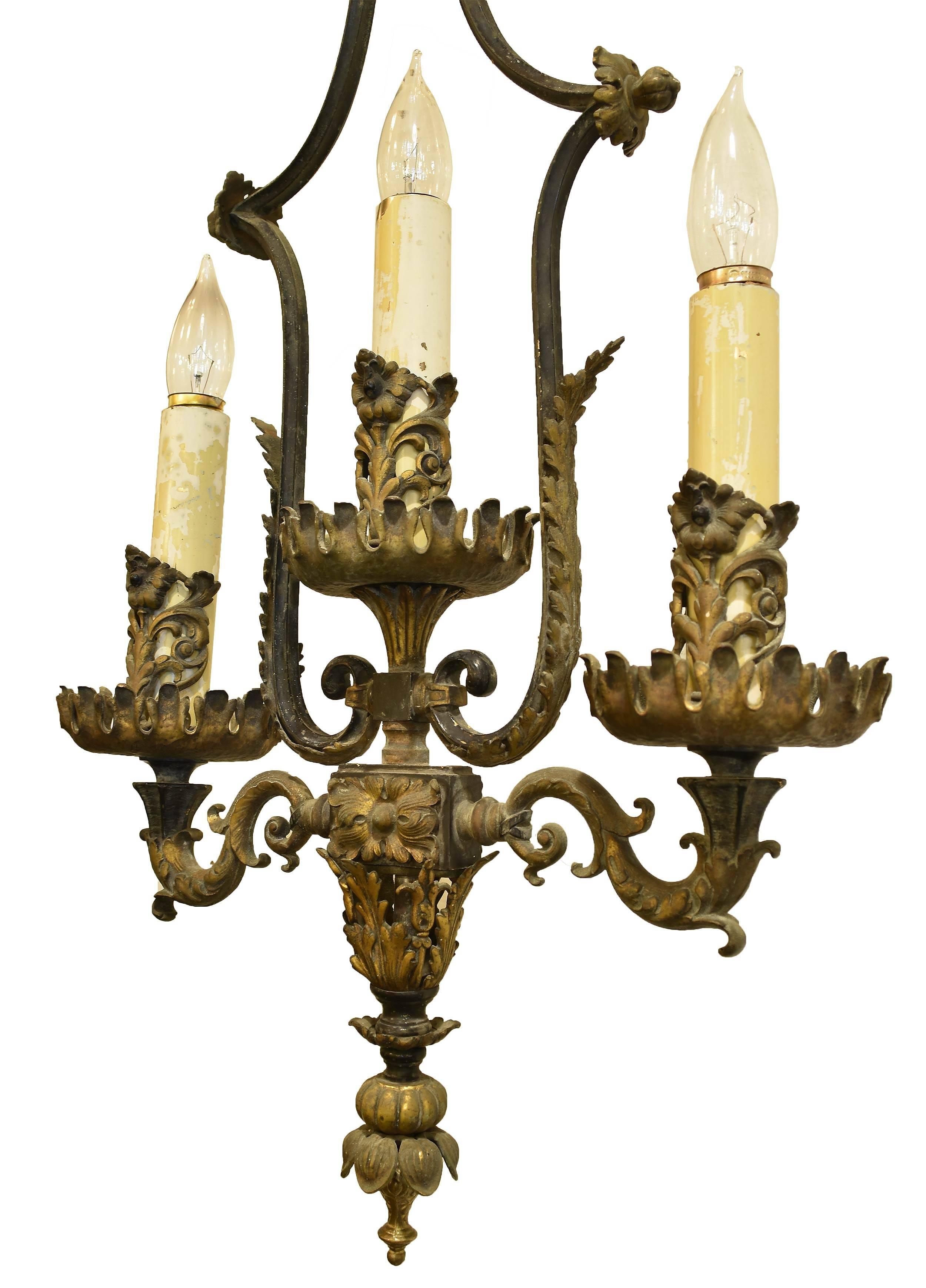 This Empire style, oversized brass and bronze sconce drapes down from its solid backplate. Each of the three candles is surrounded with a centre flower and garland at its base. Solid construction with a open wispy feeling. Stately in any foyer,