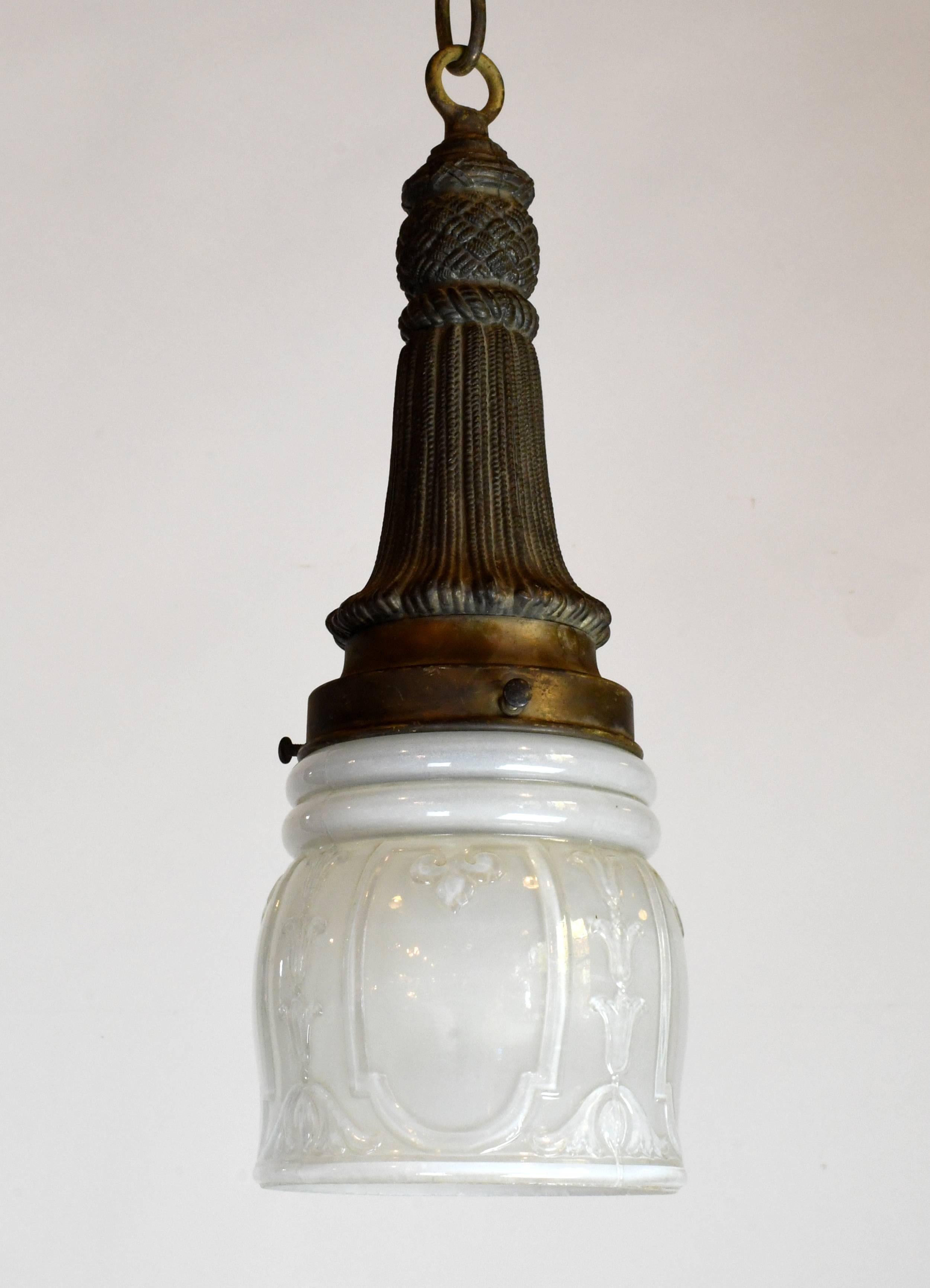 The glass shade of this pendant is decorated with floral patterns, while tassel embellishments and crosshatch patterns weave throughout the fixture itself.

circa 1920
Condition: Excellent
Finish: Original
Country of origin: USA
1 medium socket

We
