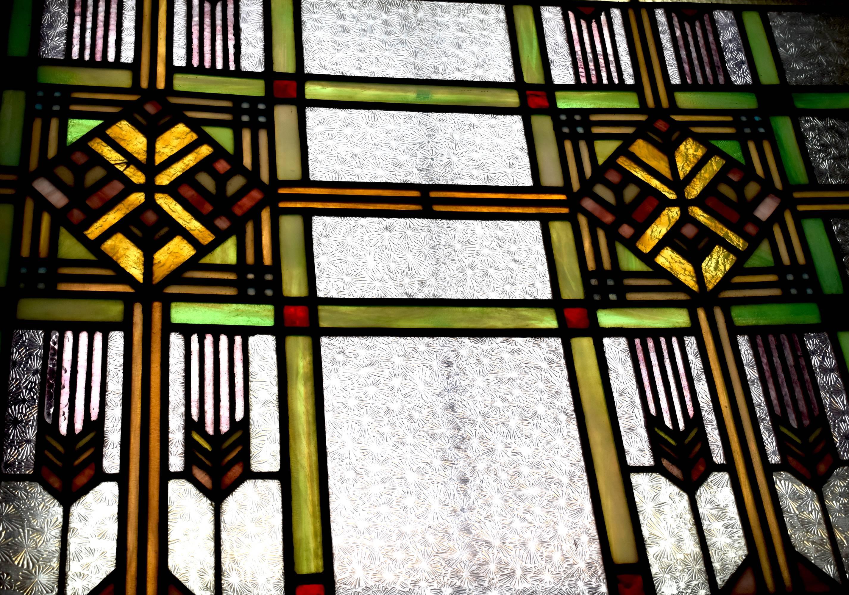 This window is a gorgeous example of the Prairie style, popular in the early 20th century and characterized by strong, defined lines and geometric shapes inspired by nature.

The second photo shows the window with natural light shining through.