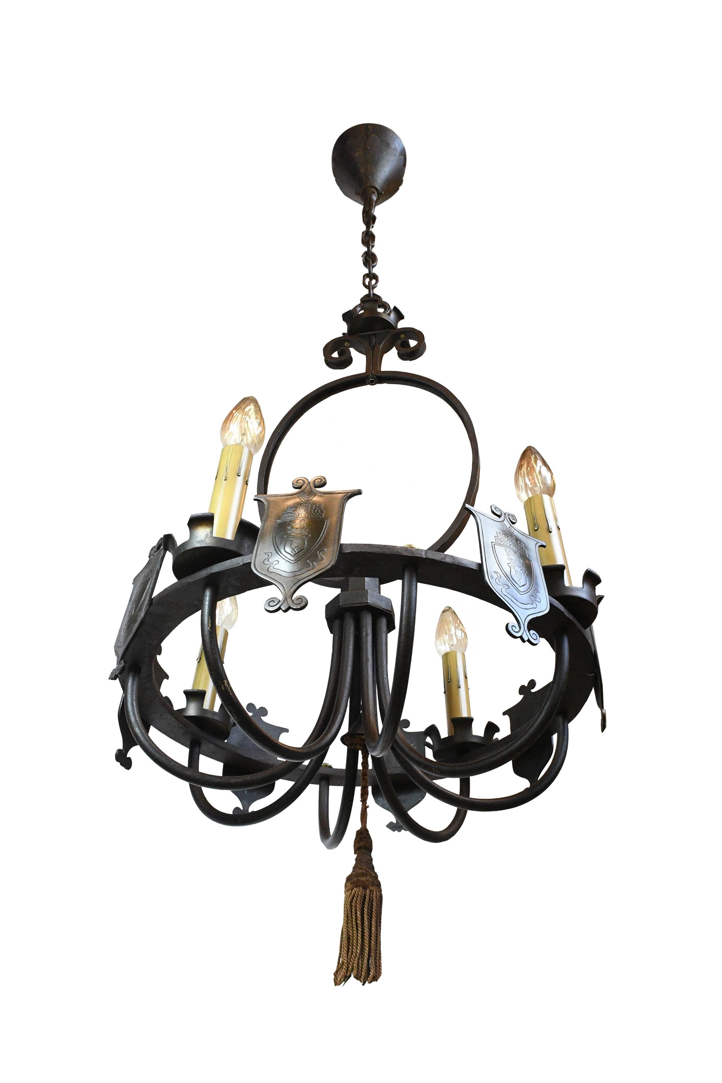 Decorative shields add a royal touch to this large iron chandelier, and sweeping, curving lines give a sense of elegance. This fixture would make a stunning addition over a dining room table, or as a focal point in a large space.

We find that
