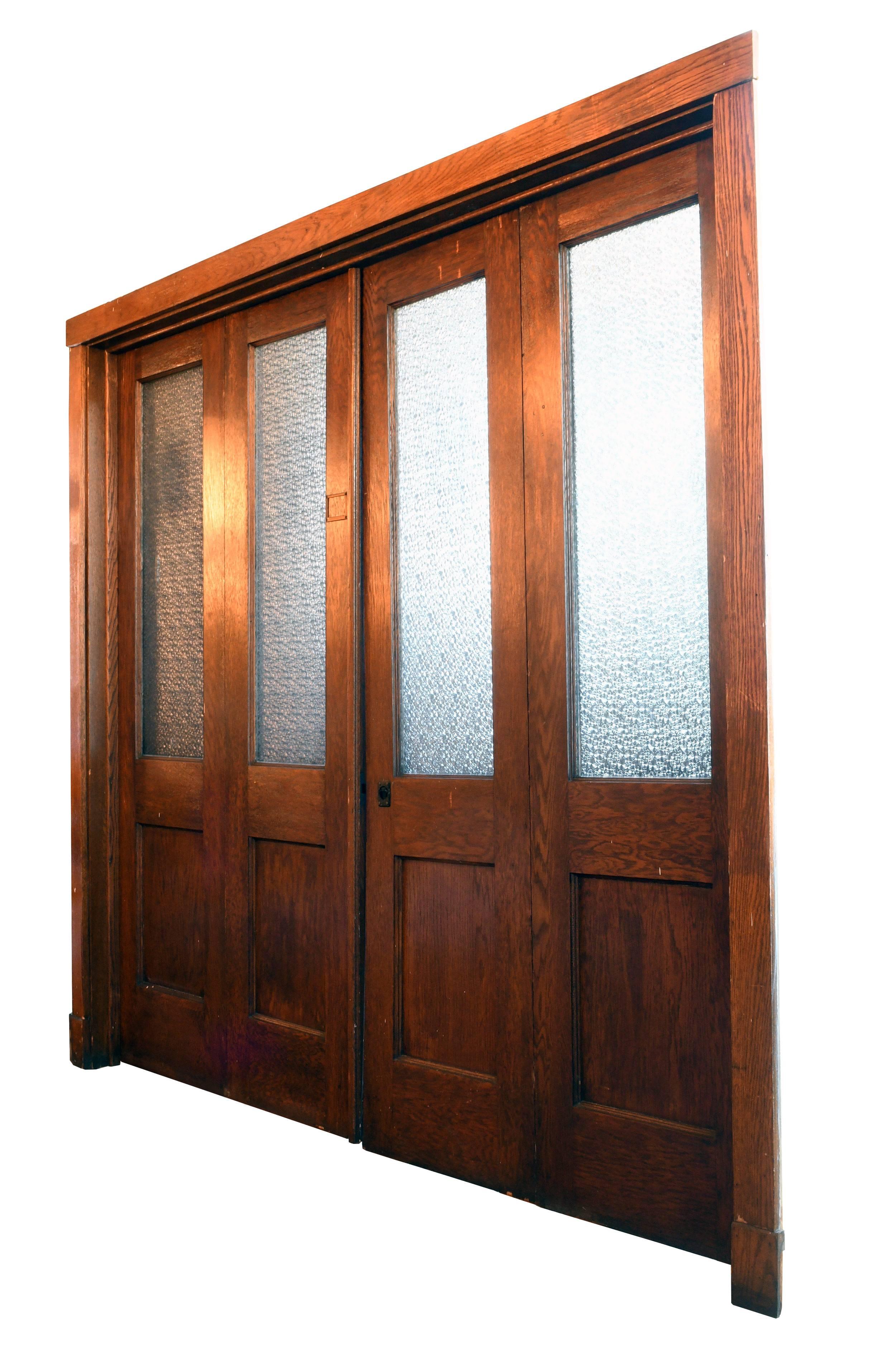 These handsome bi-fold doors originally came from a school in Youngstown, Ohio. Made of oak and stained a rich brown, the wood is in excellent condition. This is noteworthy, considering that the doors spent nearly a century in a school among