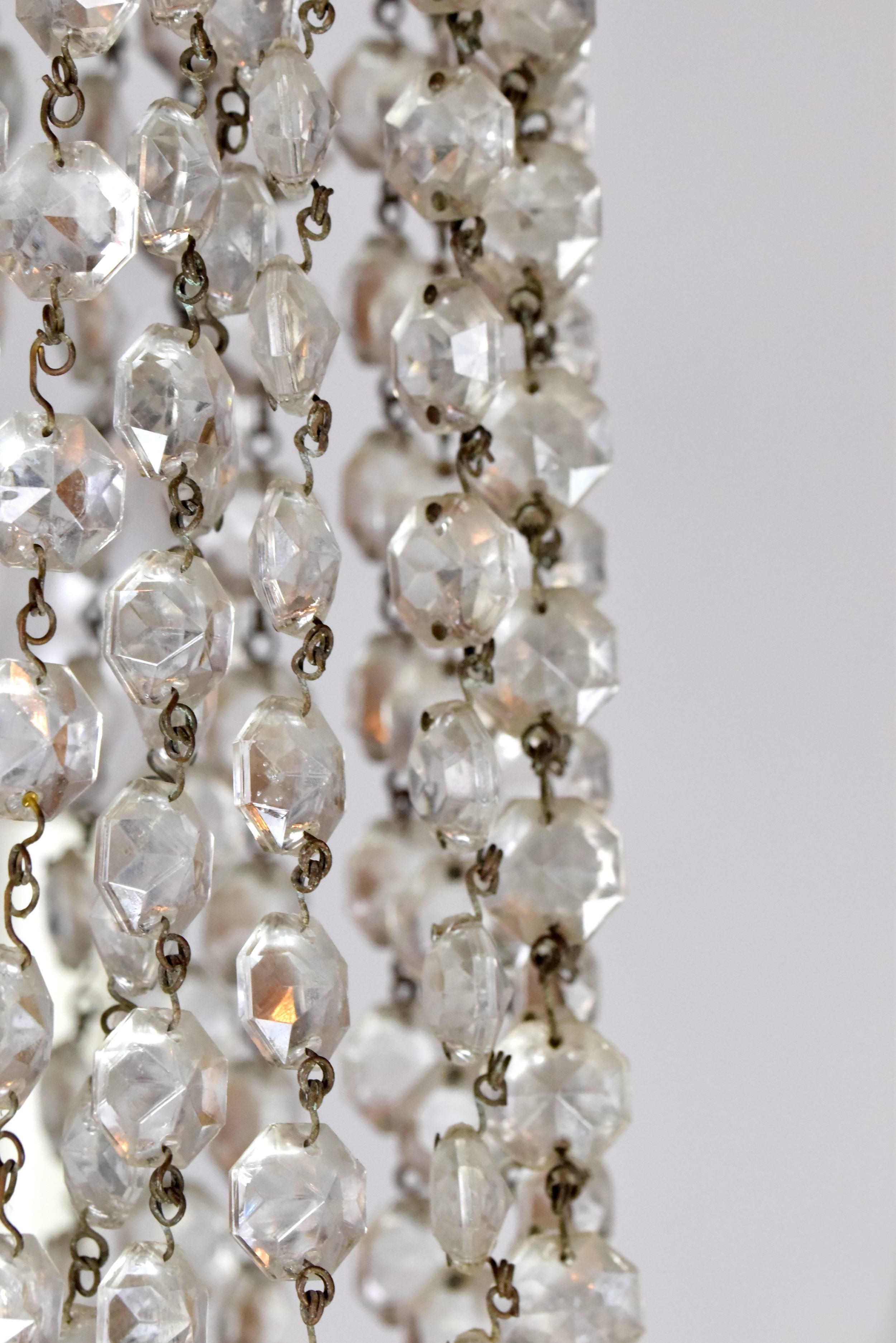 Tall, staggered candlesticks, myriad glinting crystals of all shapes and sizes, and elegantly sweeping arms give this chandelier an air of sophistication and glamour. Small crystals cascade from top to bottom, creating a blanket effect of rich