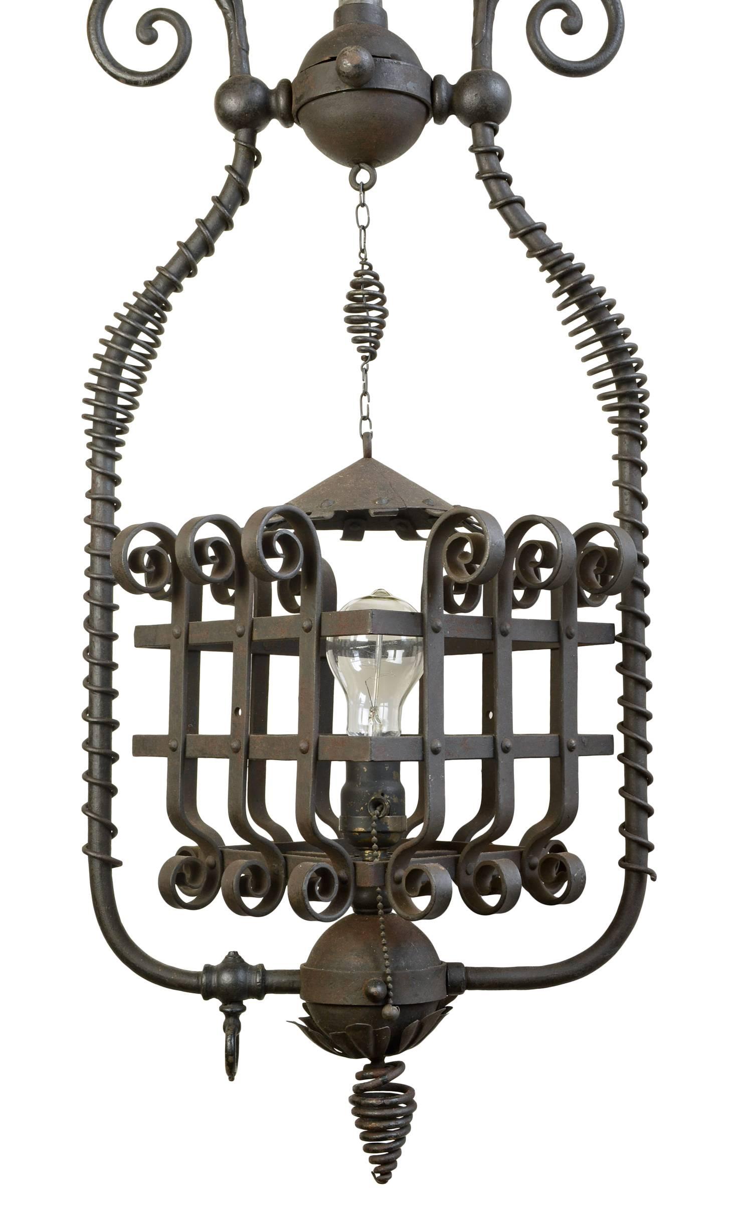 This unusual fixture contains fanciful scrolls that gracefully wrap around the harp, varying in diameter to give the fixture a feeling of whimsy and to emphasize its shape and line. Originally a gas lamp, it has been converted to an electric pendant