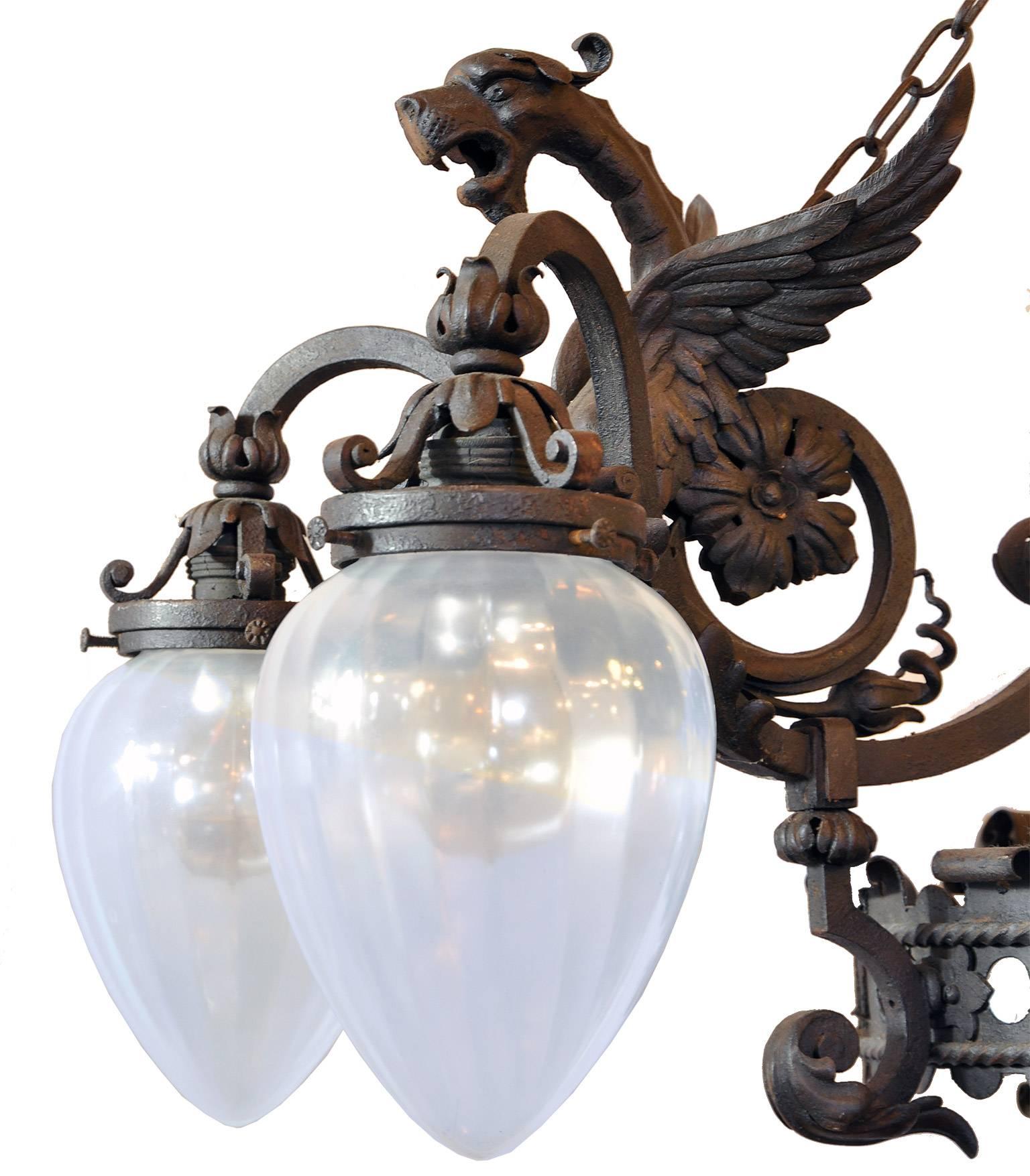 This massive five-light fixture, created circa 1880, is a wonderful example of quality craftsmanship and lighting at the turn of the century. The craftsman took a standard style of the time period and decked it out with medieval dragon details and