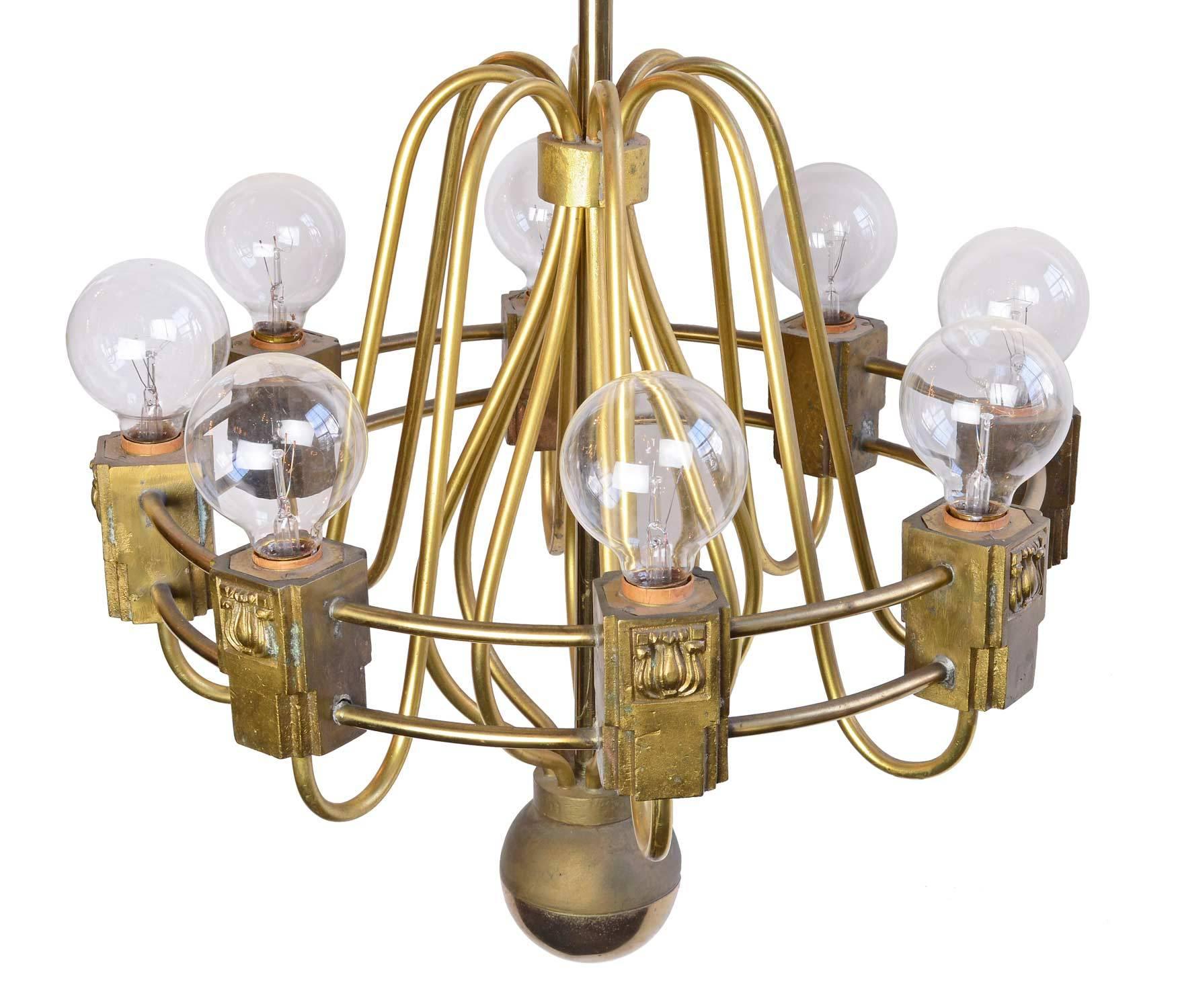 Stunning lines and fabulous cast brass details are featured in this Midcentury style light. Eight bent brass arms gracefully curve and connect to two brass bands, finishing off with a heavy cast lamp holder with fine Art Deco details. Multiple