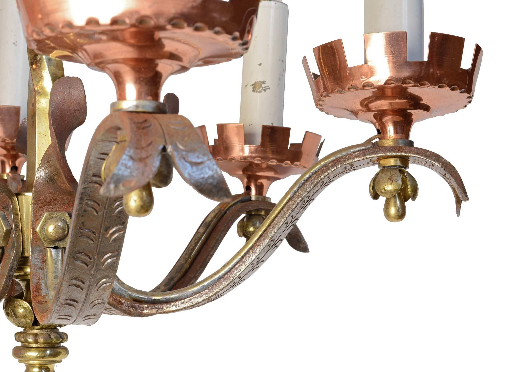 This six-candle Gothic Revival chandelier is a beautiful mix of many metals and textures. The fixture's heavy cast brass body and finials, flared cast iron arms with decorative ornamentation, and copper bobeches combine to create a dynamic piece.