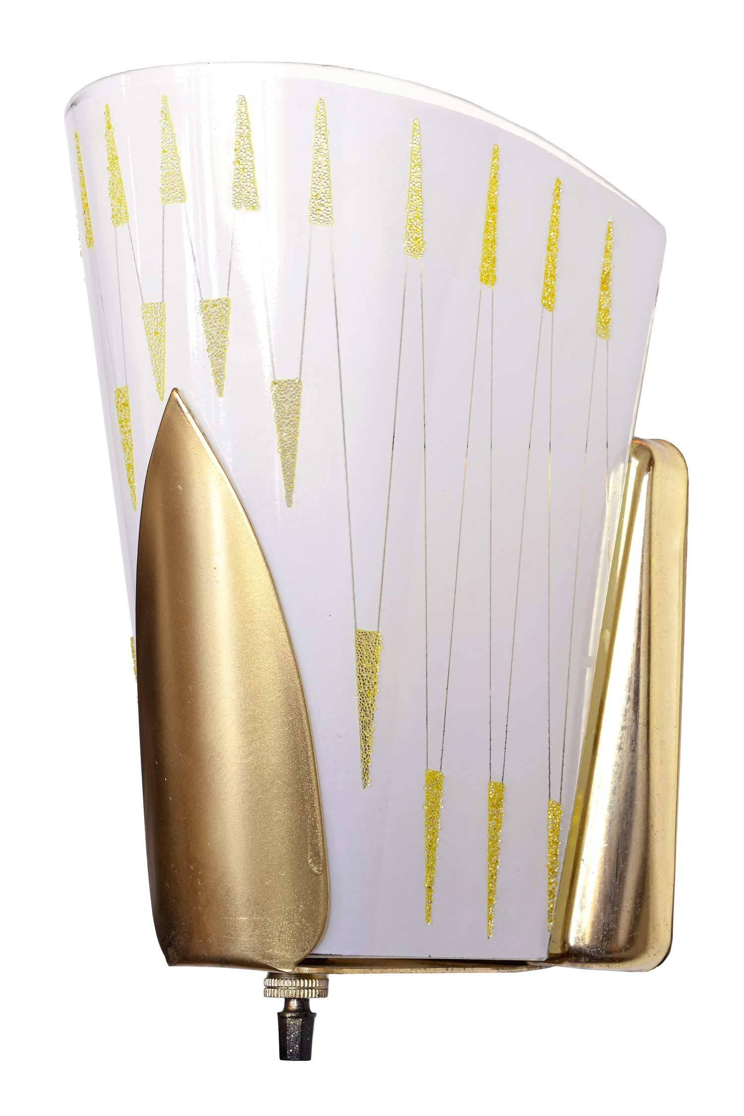 These Midcentury sconces have a streamlined look and a geometric pattern. Raised gold stencil decorates the milk glass shade which is held by a brass sconce body.

We find that early antique lighting was designed as objects of art and we treat each