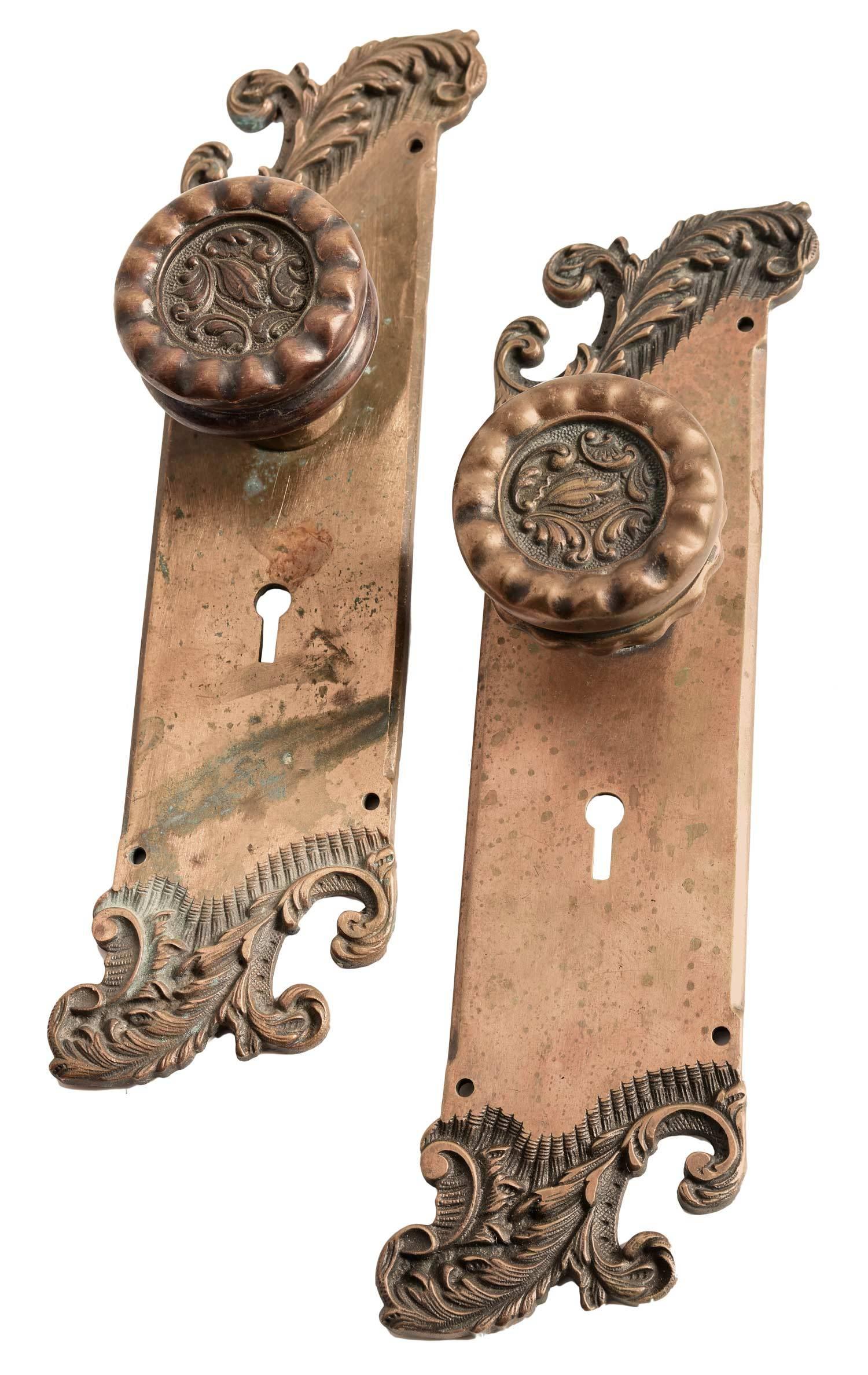 Americus bronze door hardware set by Reading Hardware Company, made of cast brass with amazing castings. This set consists of four backplates, two with a hammered finish and two with a smooth finish, and four matching knobs featuring acanthus leaf