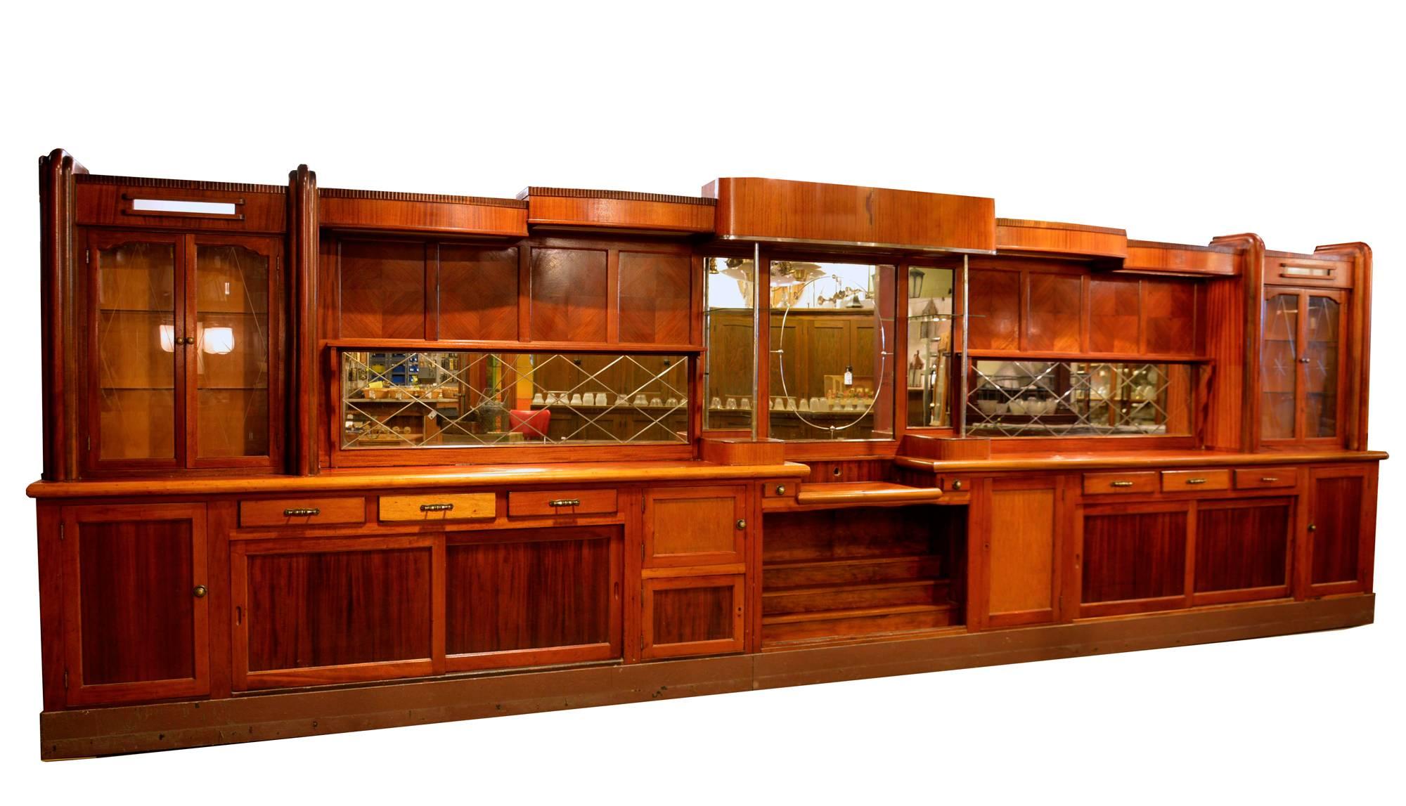 This is a great piece! It has etched glass doors with a star burst pattern, diamond parquetry panels in the back bar, lots of drawers and diamonded beveled mirrors. The front bar is in good shape with lovely mahogany veneer and a solid top.
Back