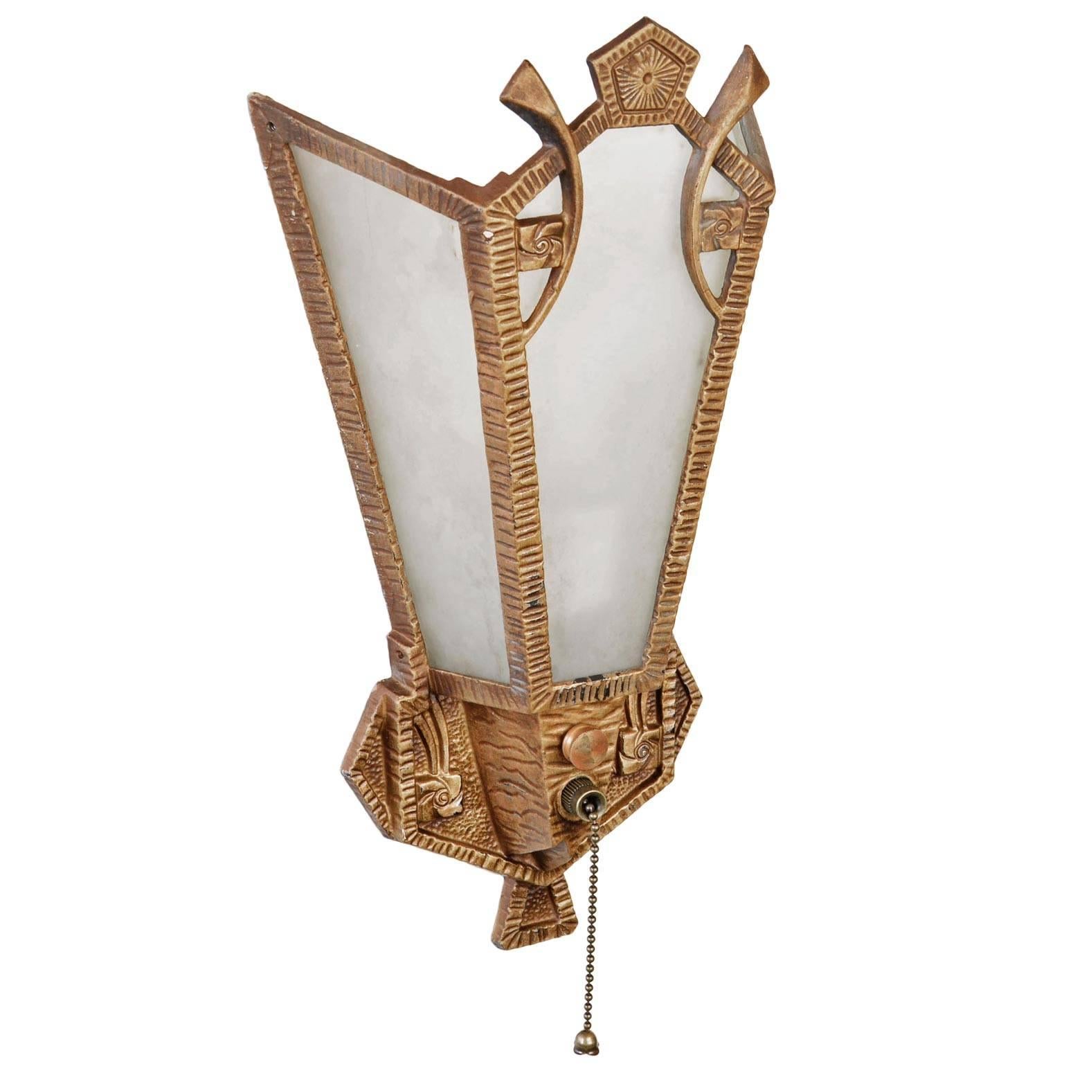 Beautiful Art Deco sconce with a body of cast aluminum with stylized floral motifs and geometric designs. Each has three etched glass panels that mount in and create a warm glow when lit. 

We find that early antique lighting was designed as objects