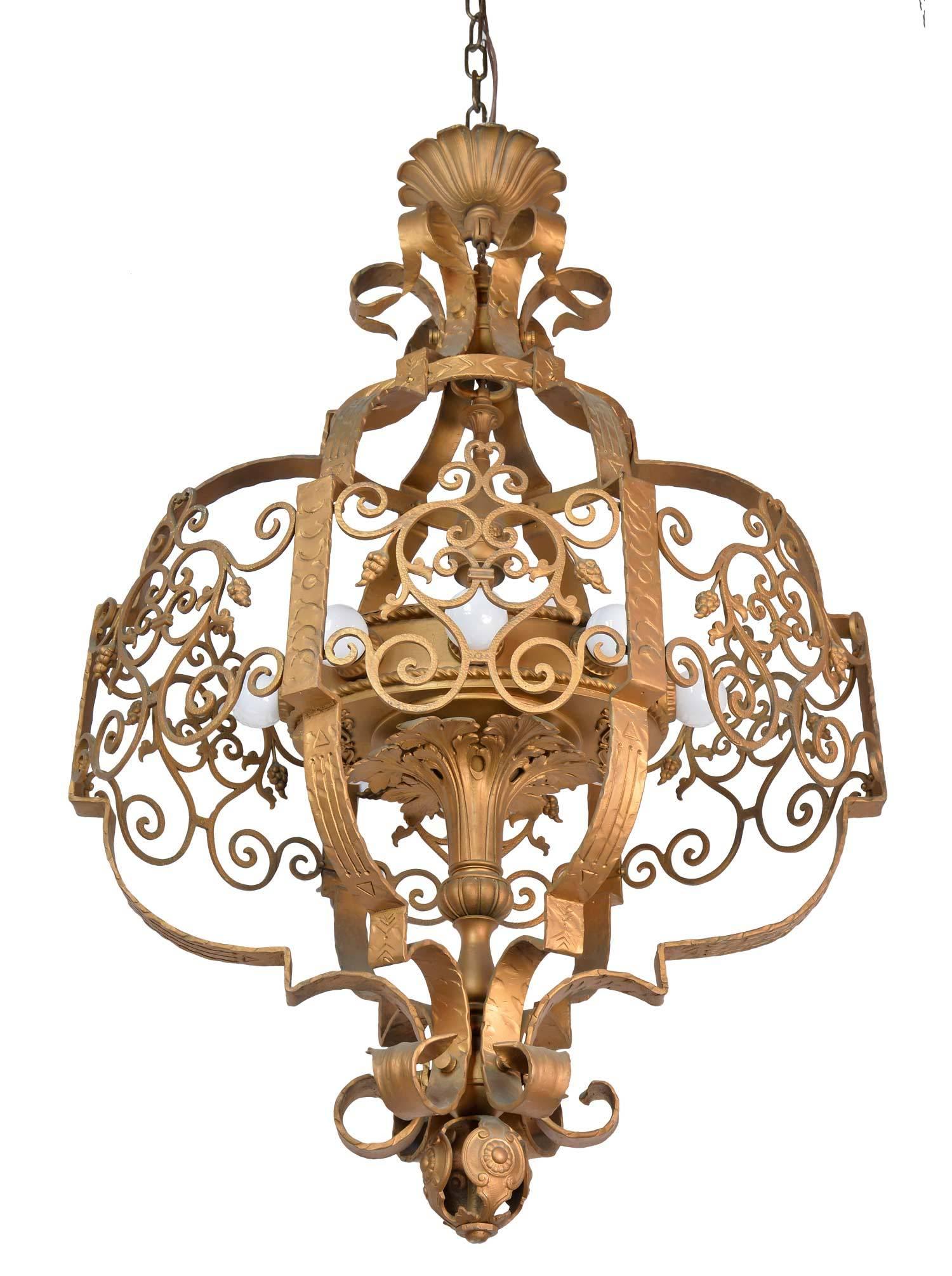 A large theatre light made of iron, ornamentation covers nearly every inch of this breathtaking fixture. Decorative scrolls surround an eight-light cluster body with medallions, acanthus leaf, and grape details. 

We find that early antique lighting
