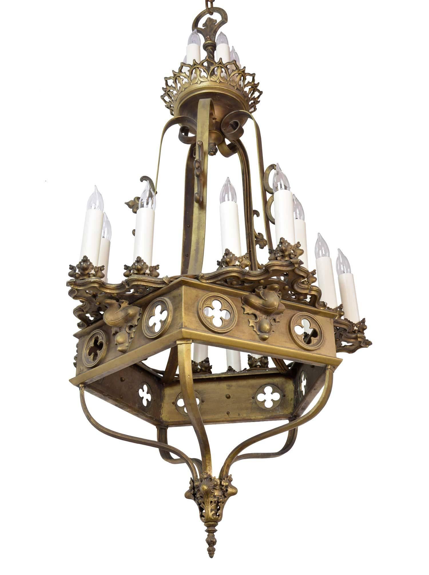 This extra large Gothic twenty-candle tiered chandelier is made from cast aluminium and painted antique brass (original finish). Each chandelier features all the standard Gothic motifs; quatrefoils, trifold and crockets. Made around 1935, they are