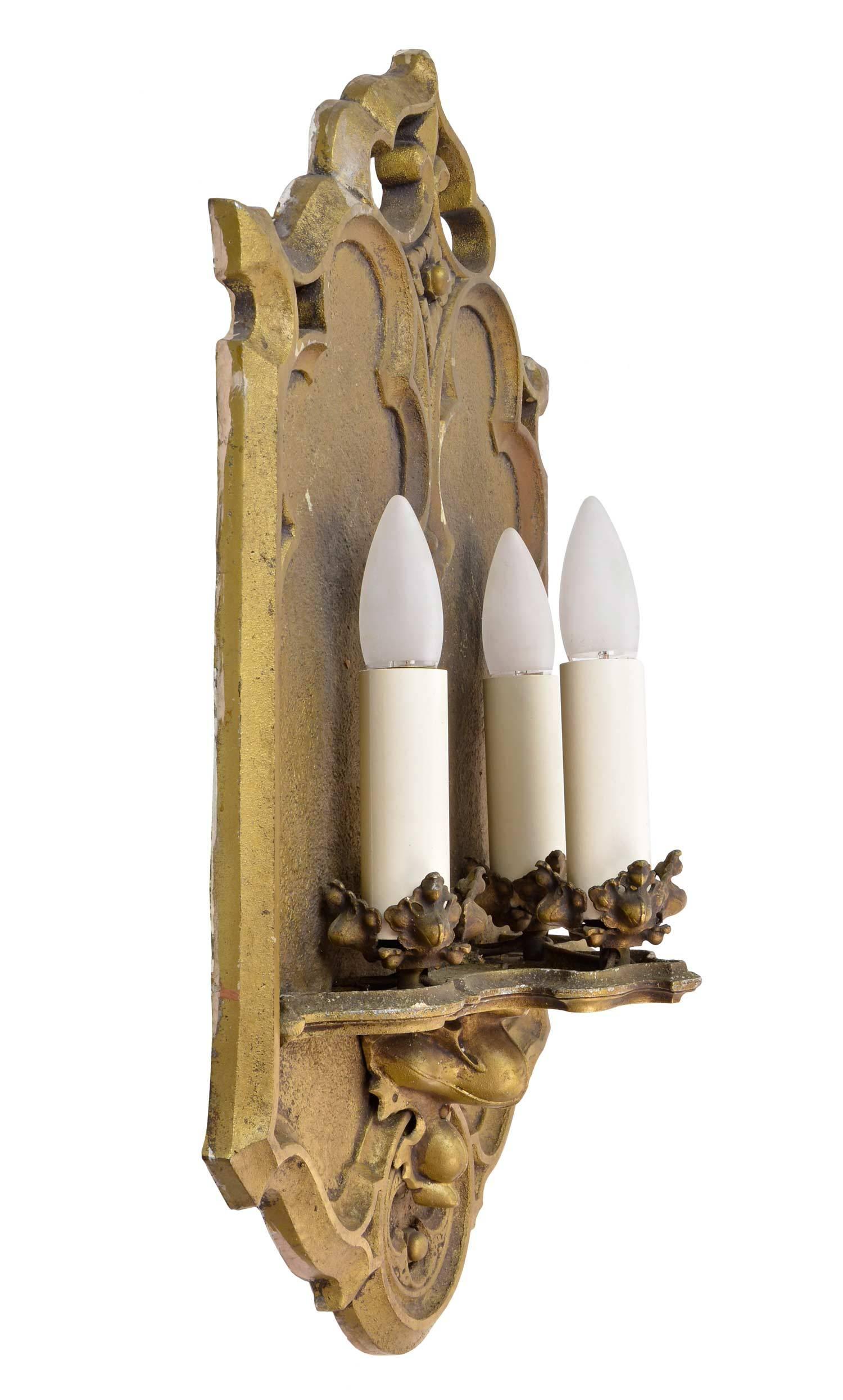 Gothic three candle sconce in cast aluminum and painted antique brass (original finish.) This sconce features all the standard Gothic motifs; quatrefoils, trifold and crockets. Made around 1935, they are still in beautiful condition. Matching