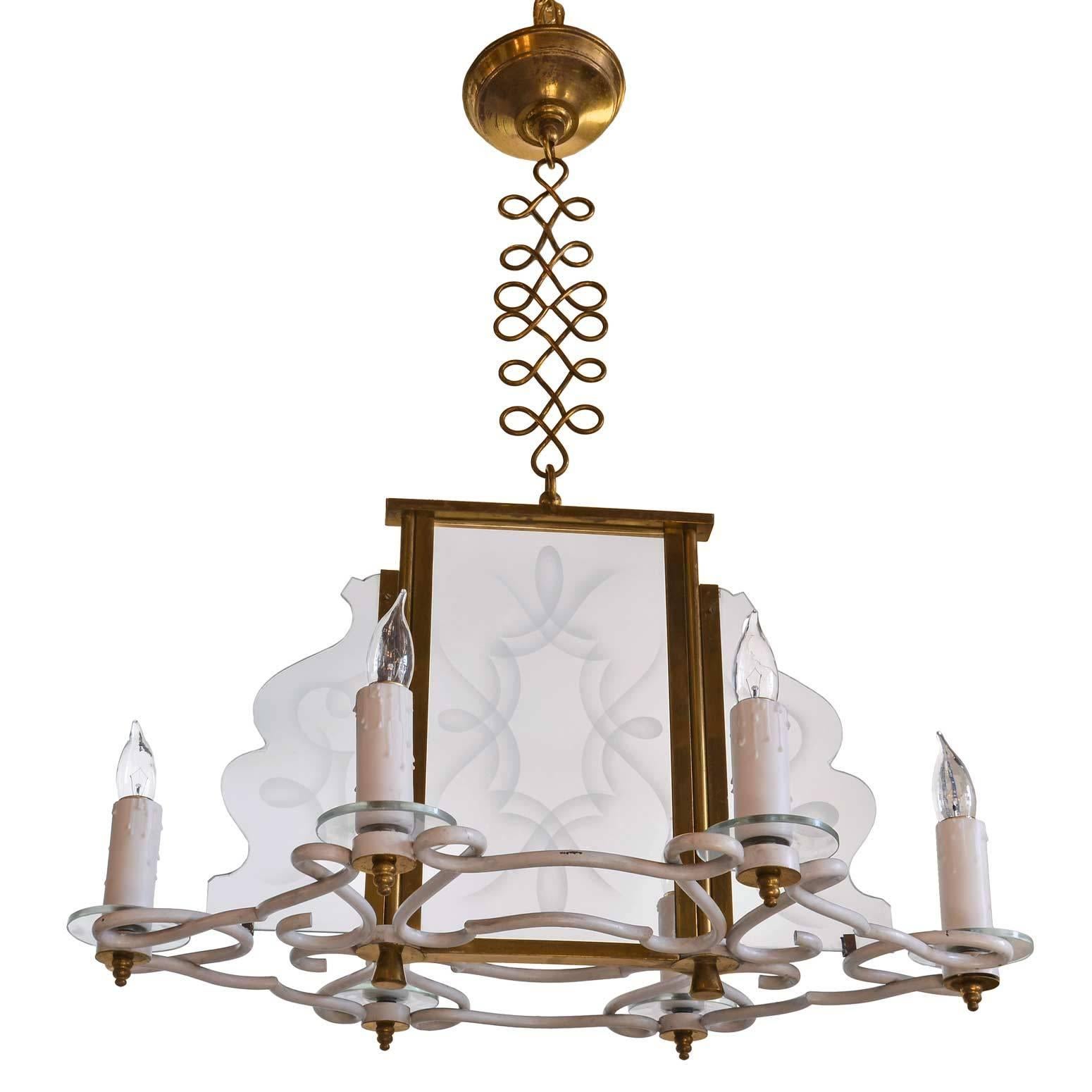 Made from brass and glass circa 1960, this chandelier features unique, cascading glass that complements the oblong, oval shape of the body. This fixture has a motif of twisting, curling shapes throughout-- the panels are etched with a curving design