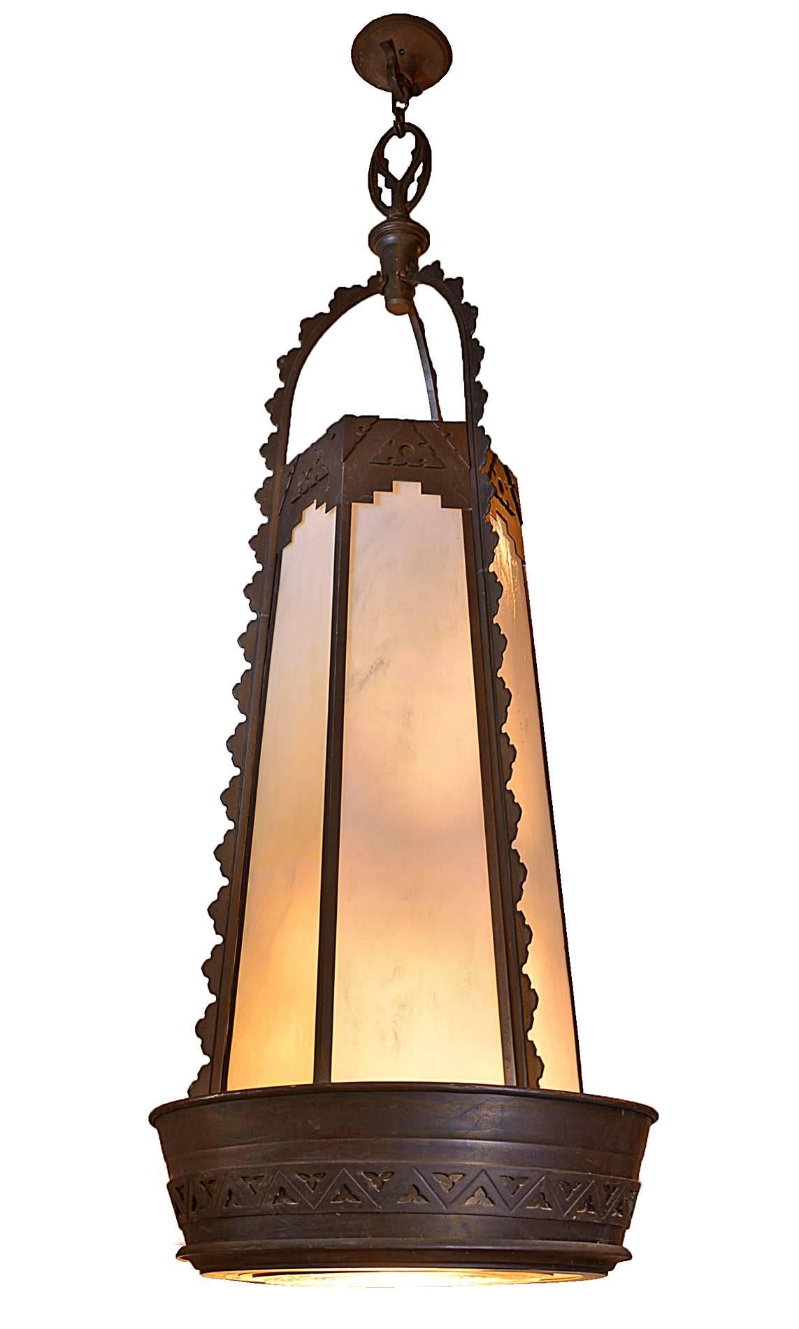 Made circa 1920 in the Art Deco style, this unusual, wonderful cast bronze pendant has stood the test of time. Heavy cast bronze with a rich patina is fashioned into an unexpected shape with geometric lines and a hint of Gothic influence. A