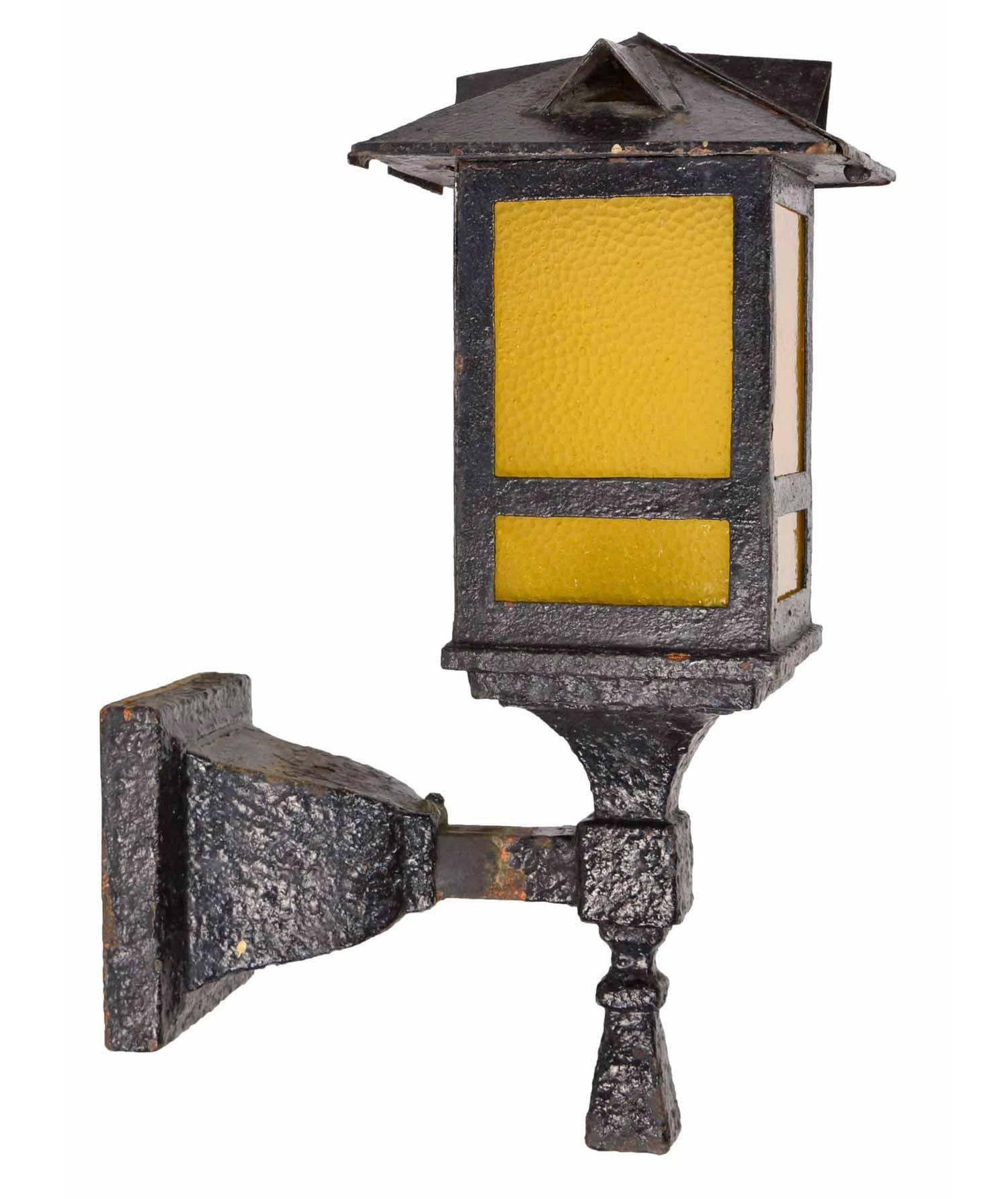 A great pair of 1920s Arts & Crafts-style exterior sconces that are made of heavy gauge cast iron. The original finish with several layers of glossy black paint with its crusty perfection adds to the fixture's charm! The top is smartly vented and