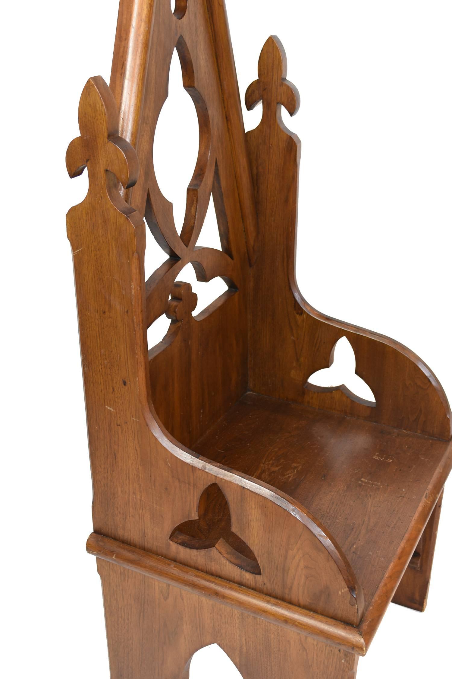 Decorative oak Bishop's chair with vaulted back featuring quatrefoil and trefoil details with fleur-de-lis.