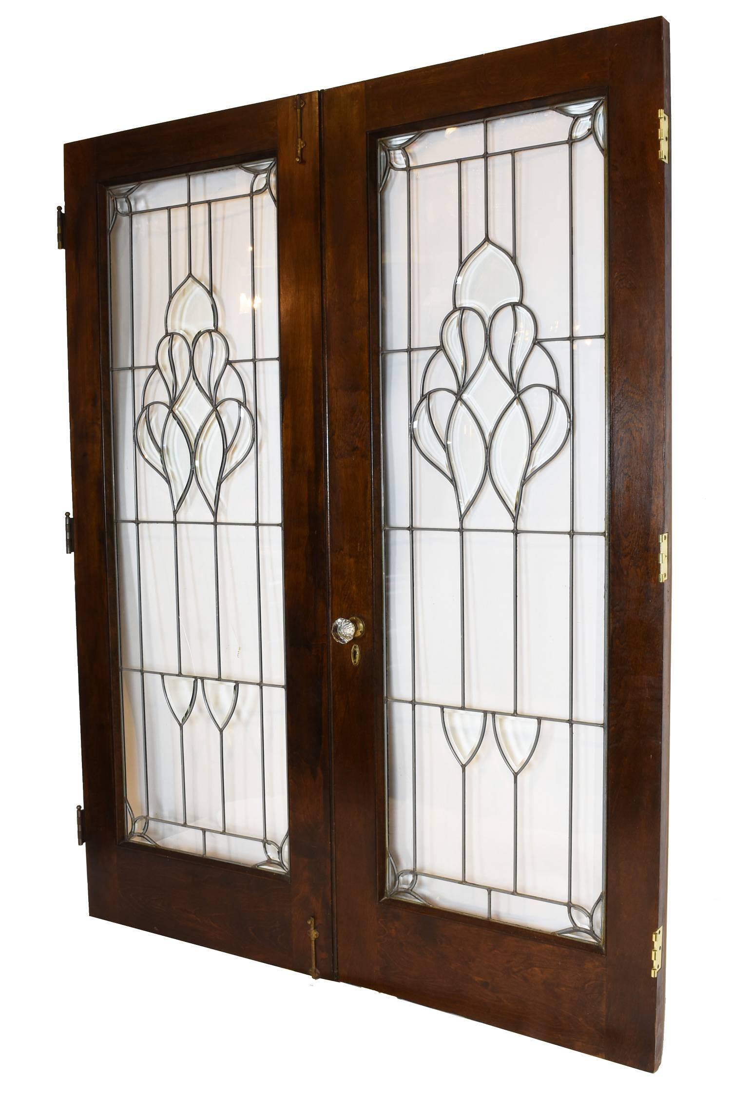 This lovely set of authentic Arts and Crafts French doors are great for allow light to transfer from room to another with a wonderful beveled glass motif. Doors come complete with original hardware, brass slide bolts and crystal door knob set. In