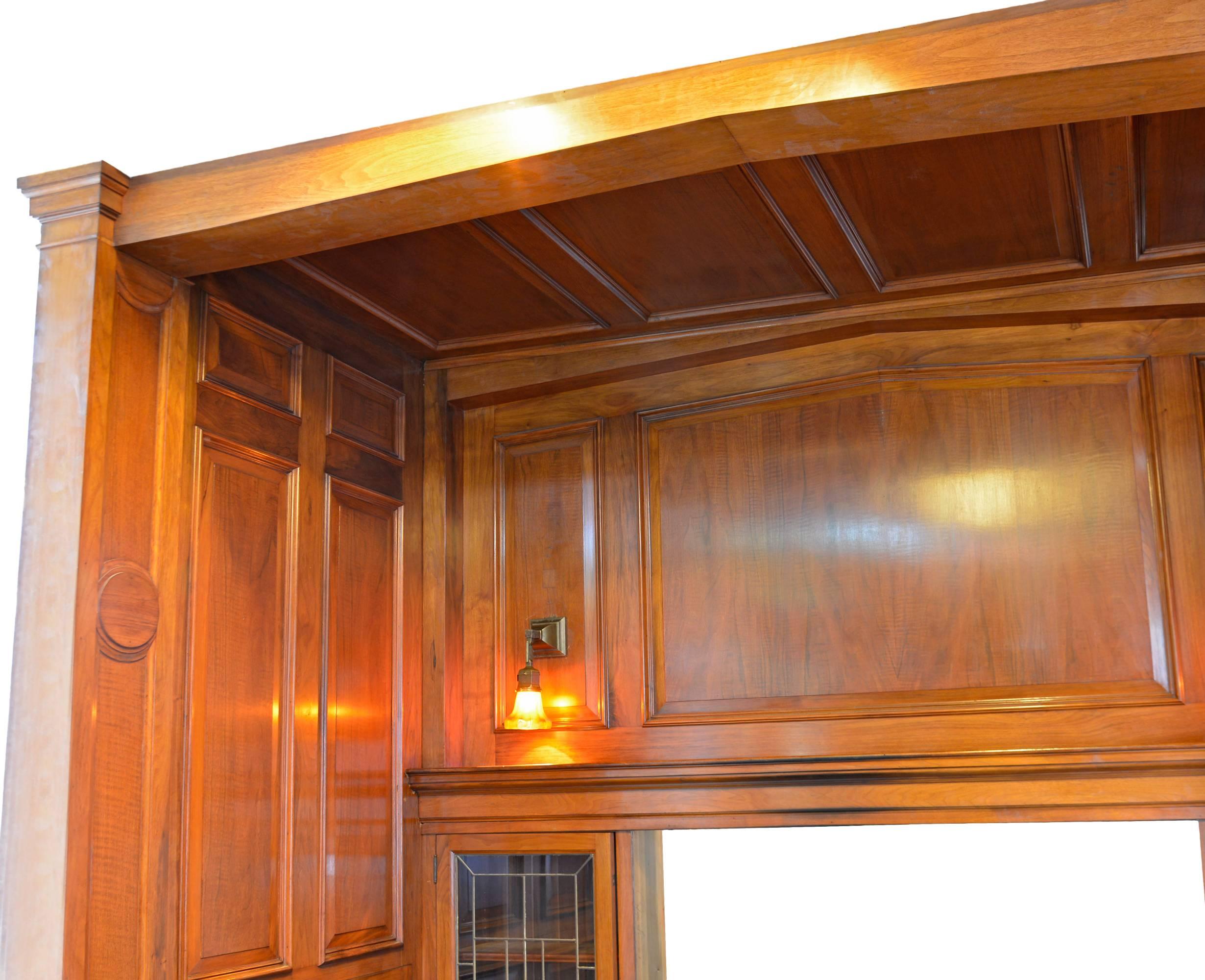 This complete walnut panelled inglennook was meticulously removed from a 1915 home. In wonderful condition, the handsome nook includes a panelled ceiling and two built-in leaded glass bookcases on either side of fireplace opening. Shown with