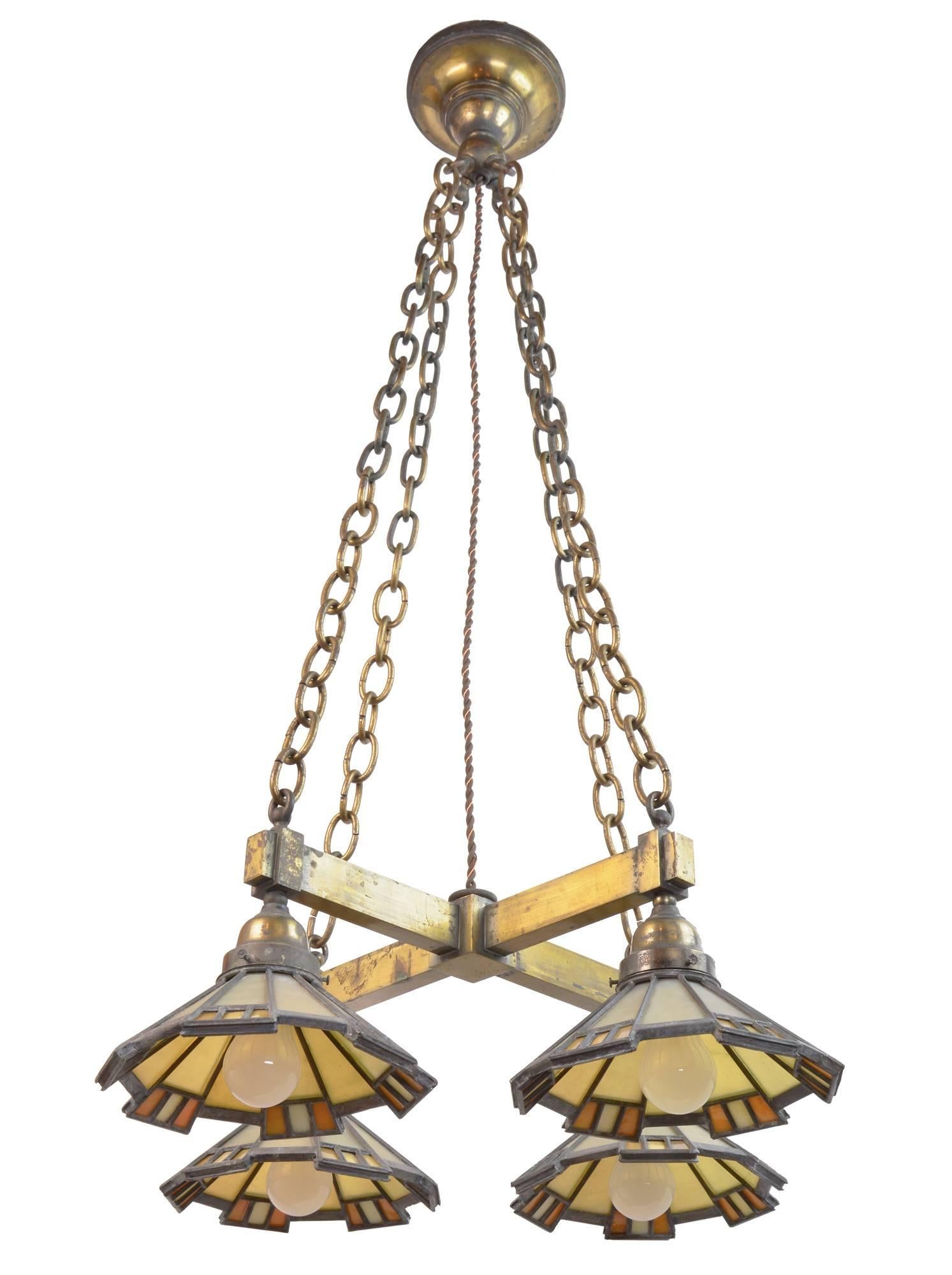 This beautiful and unique brass four-light Mission chandelier has a set of art glass shades in rich tones of amber and yellow glass. Original from sizable home in the Minneapolis area, the iridescent quality of glass and craftsman ship of the