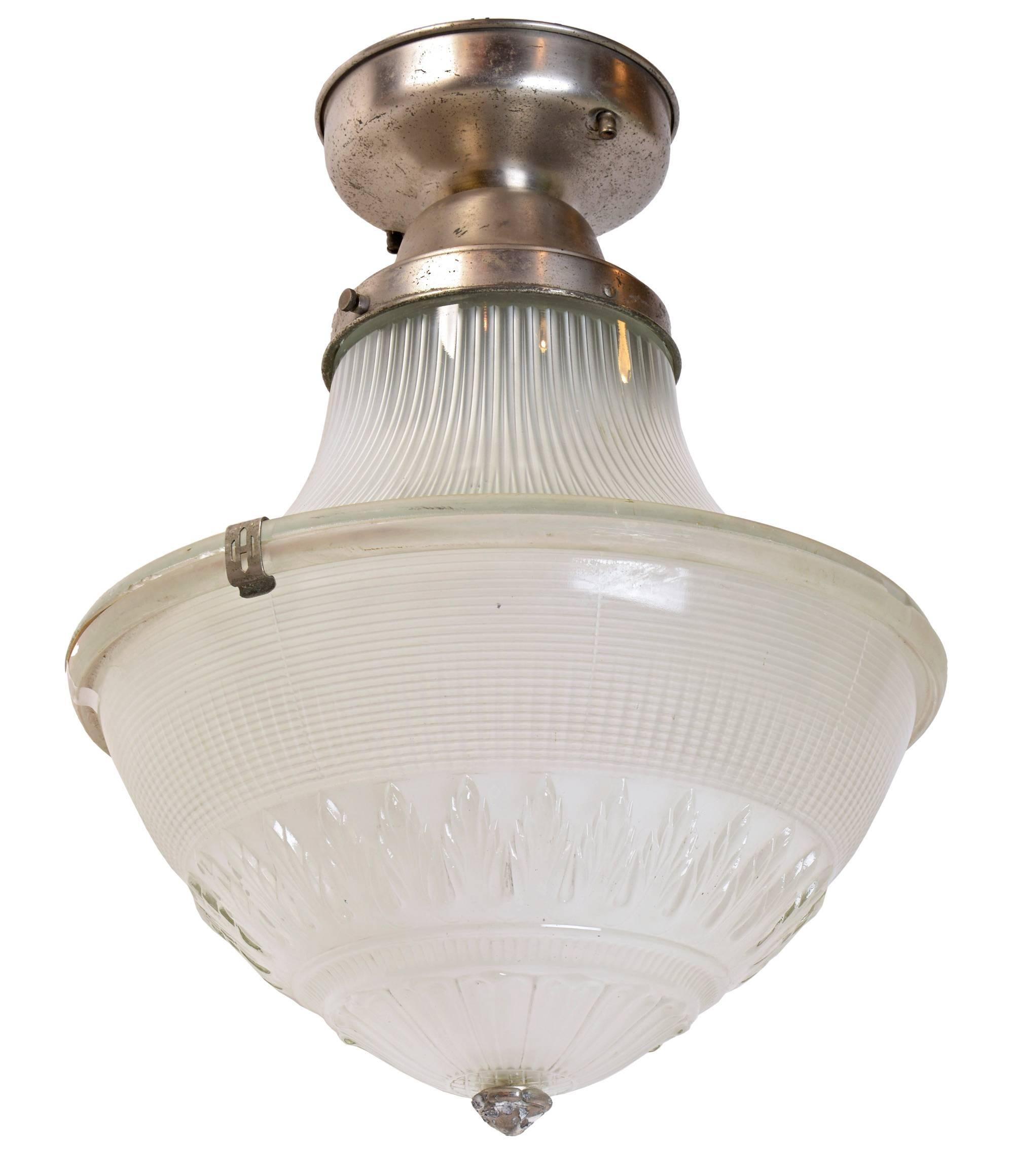With its beautiful patterning, this 1923 holophane flush mount brings a sense of airiness and historic character to any room. A nickel-plated fitter holds the fixture's unique three-piece globe, comprised of a ribbed upper shade, a decorative lower