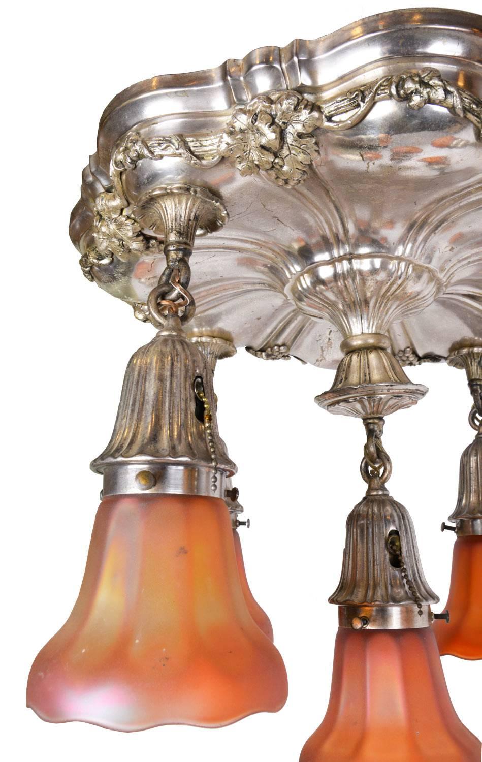 This beautiful semi-flush Sheffield chandelier has finely executed ornate floral and organic details in silver plate over brass. The Beaux Arts-style fixture is attributed to Beardslee Chandelier Company, made circa 1915. Rich colors from the