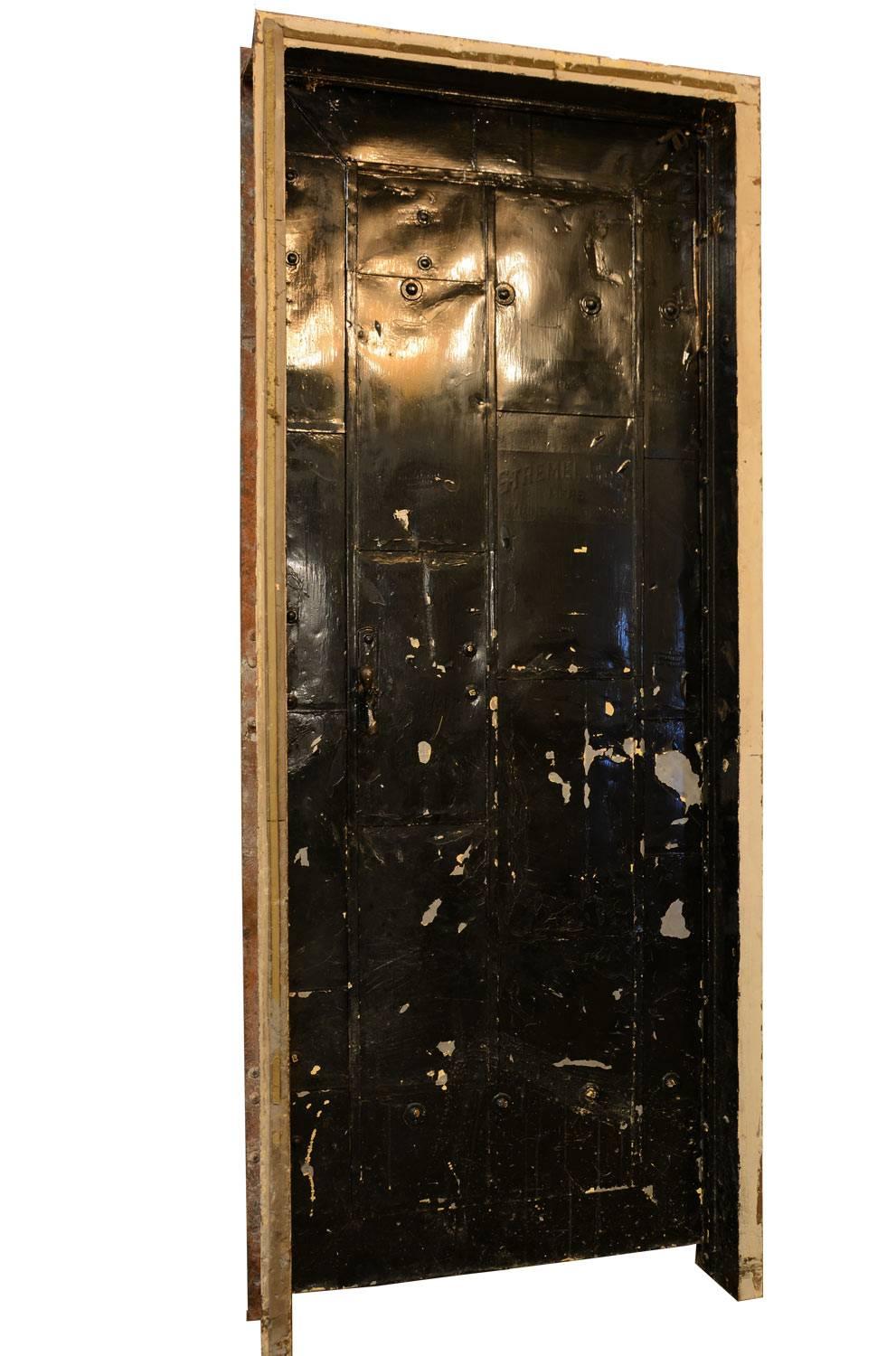 Heavy duty black, metal clad fire door produced by Stremel Bros. in Minneapolis, circa 1920s. Complete with original strap hinges, latch system and iron frame for easy installation. 

 