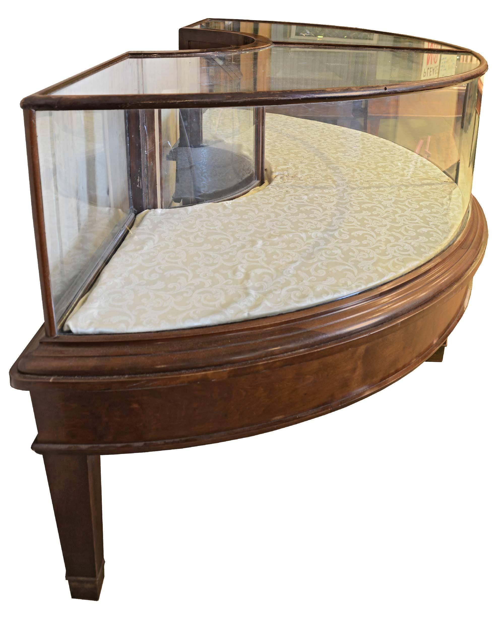 This display case is made of mahogany and curved glass, with curved doors in the back that slide down. Manufactured by C.F. Jorgeson & Co of Chicago, IL.

Measures: 86