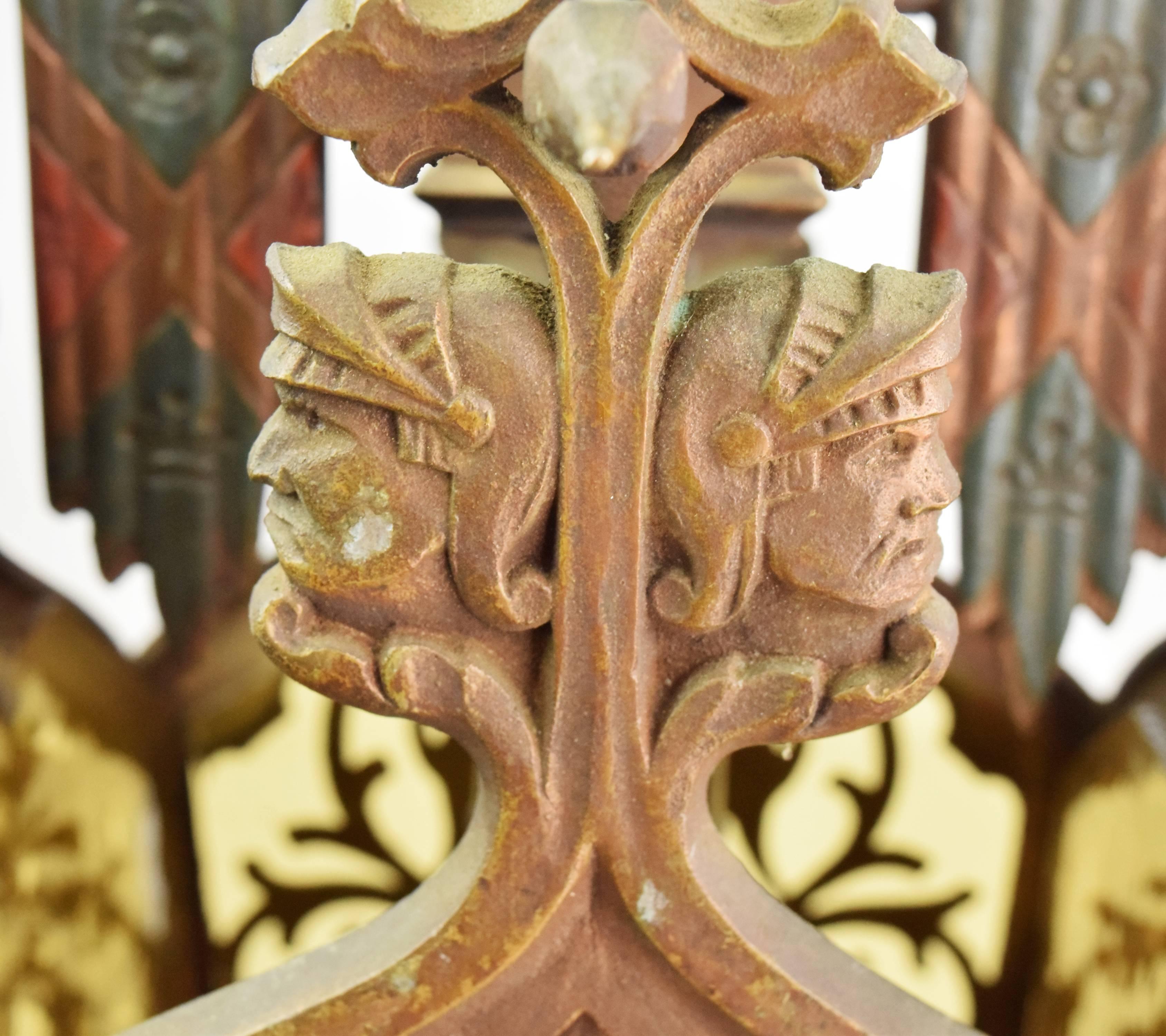 This beautiful cast brass Tudor pendant has four beautiful amber glass panels and features an array of intricate, decorative elements throughout. On the main body of the fixture you can find birds, lions, grapes, floral elements, and a few faces.