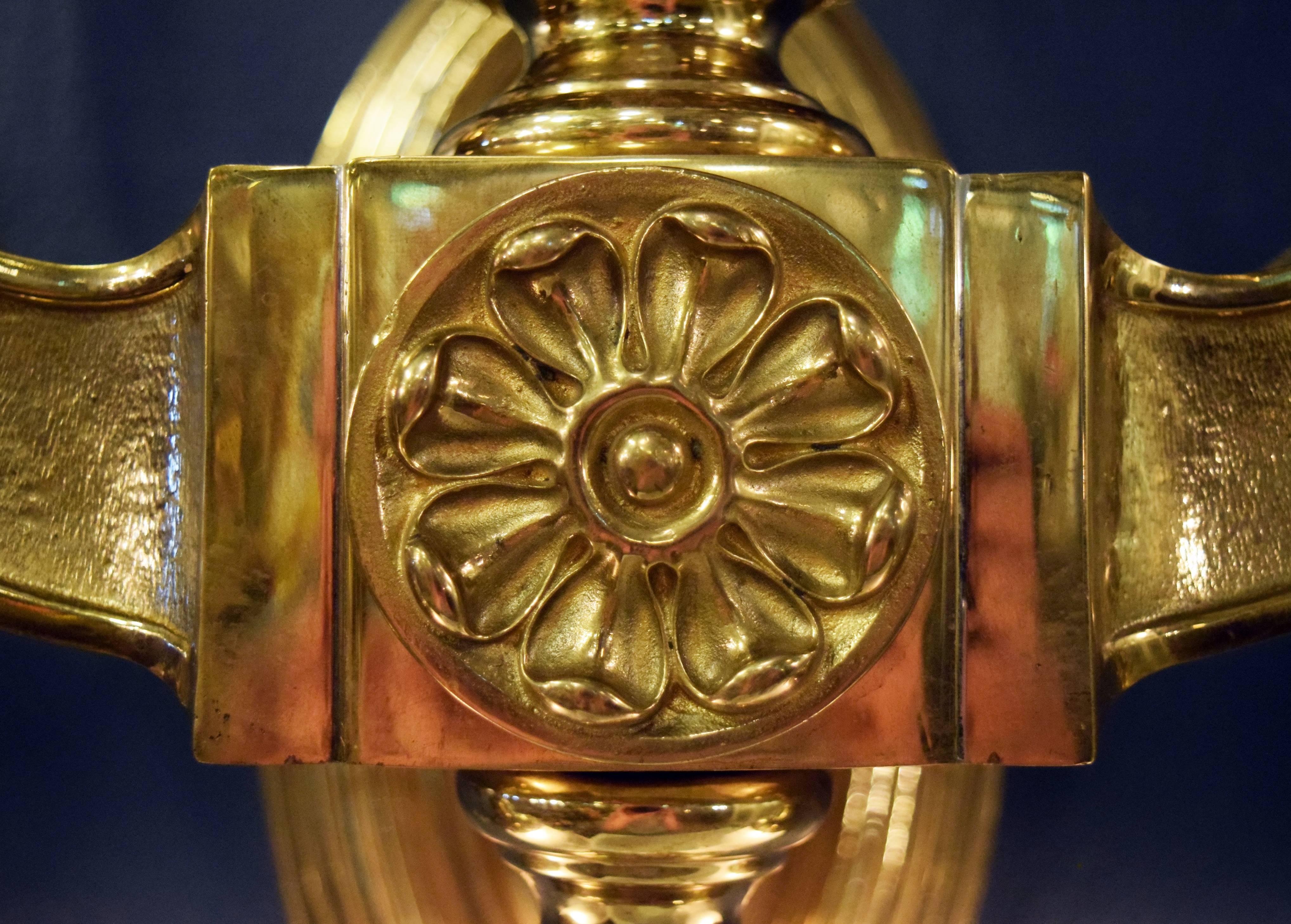 These heavy cast brass neoclassical sconces are wonderfully unique and feature beautiful decoration throughout! The elegant, delicate floral decoration on the center of the body along with other organic, curving design elements balance out the heavy