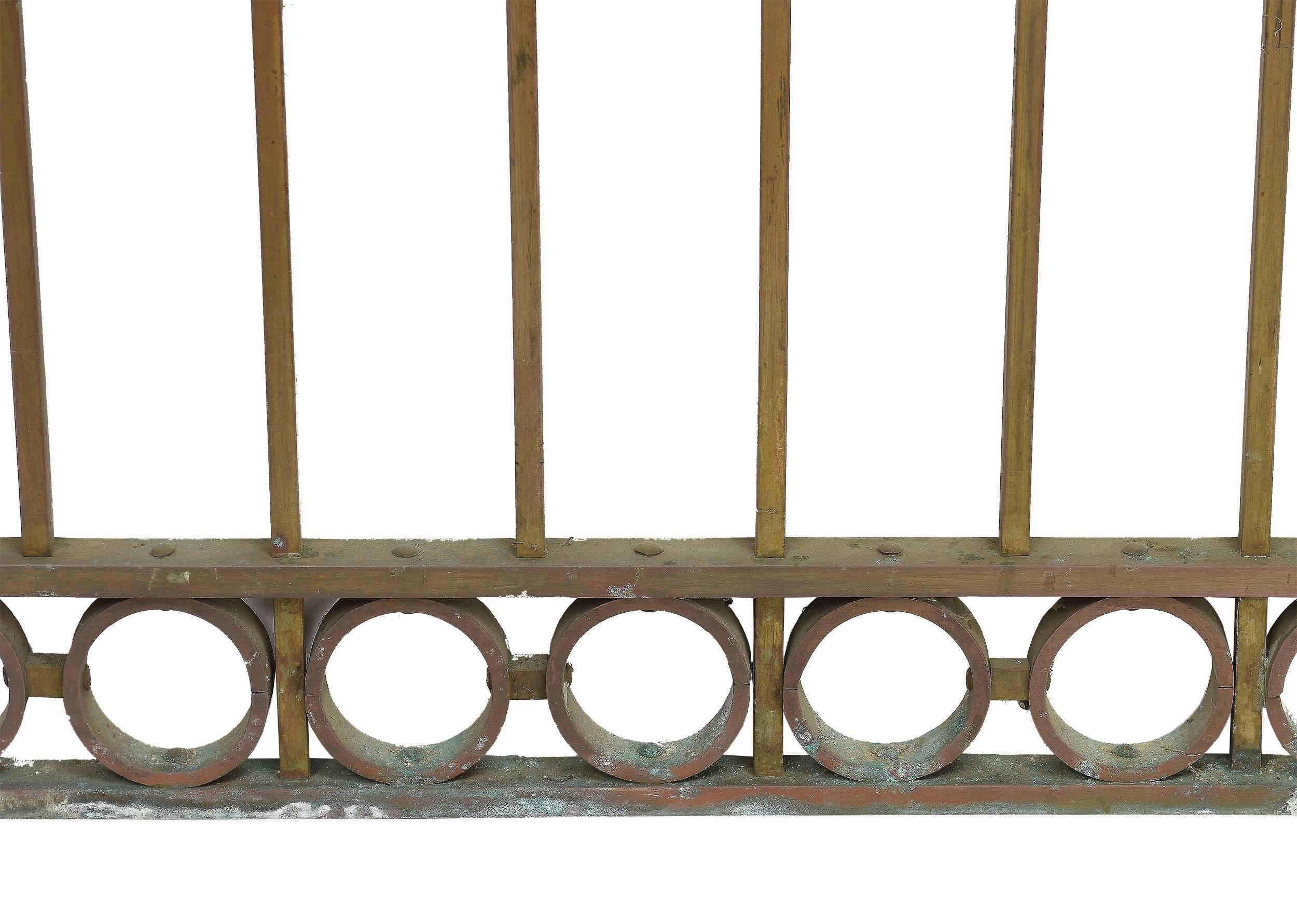 You won't find teller window gates like these at any modern bank! Made of cast bronze, they feature square bars running the length of the gate and decorative curving details at the top and bottom.