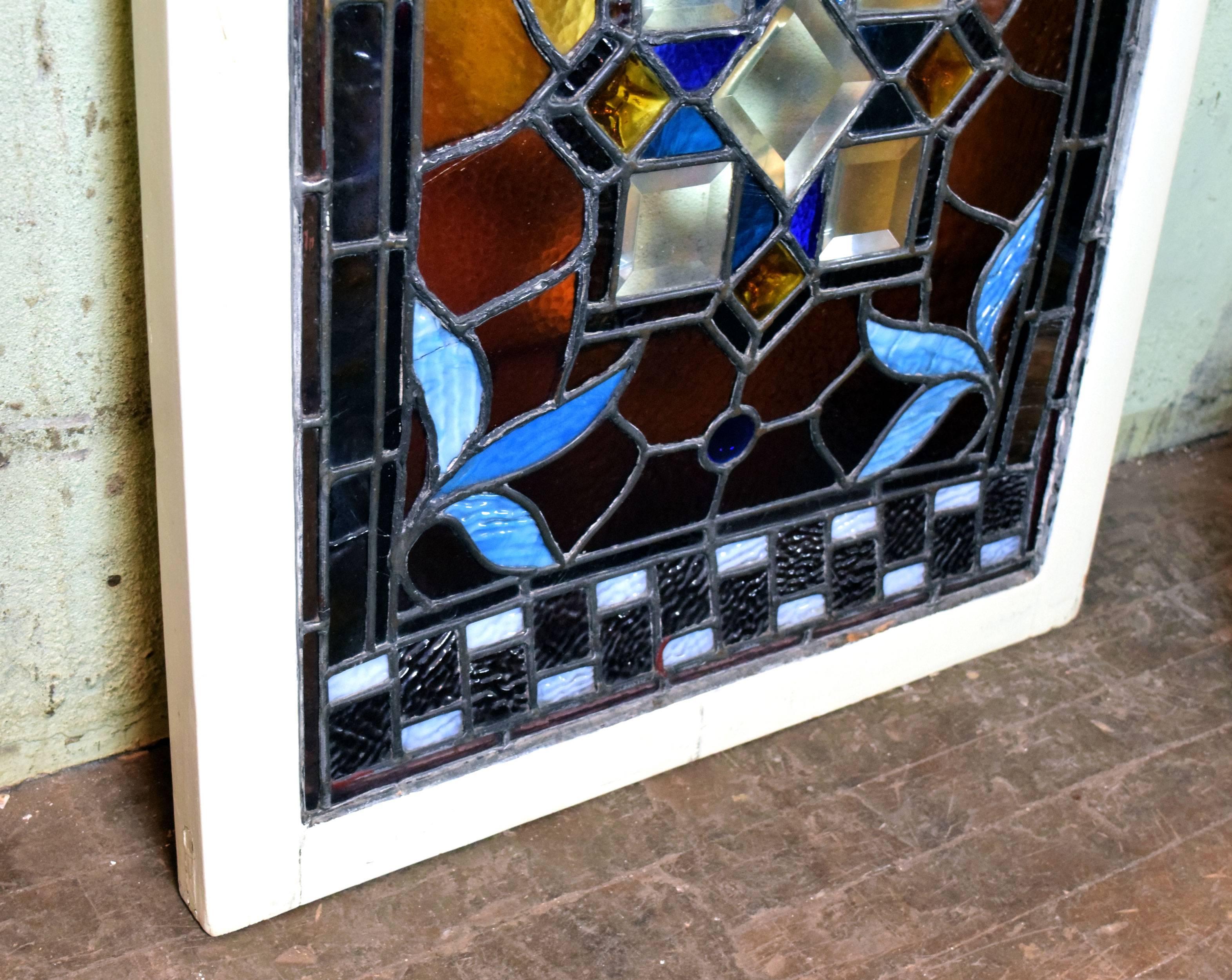 This Victorian window features a central clear beveled square motif. Gold, amber, blue and violet colors accent the sweet, simple design. A unique, one-of-a-kind window!