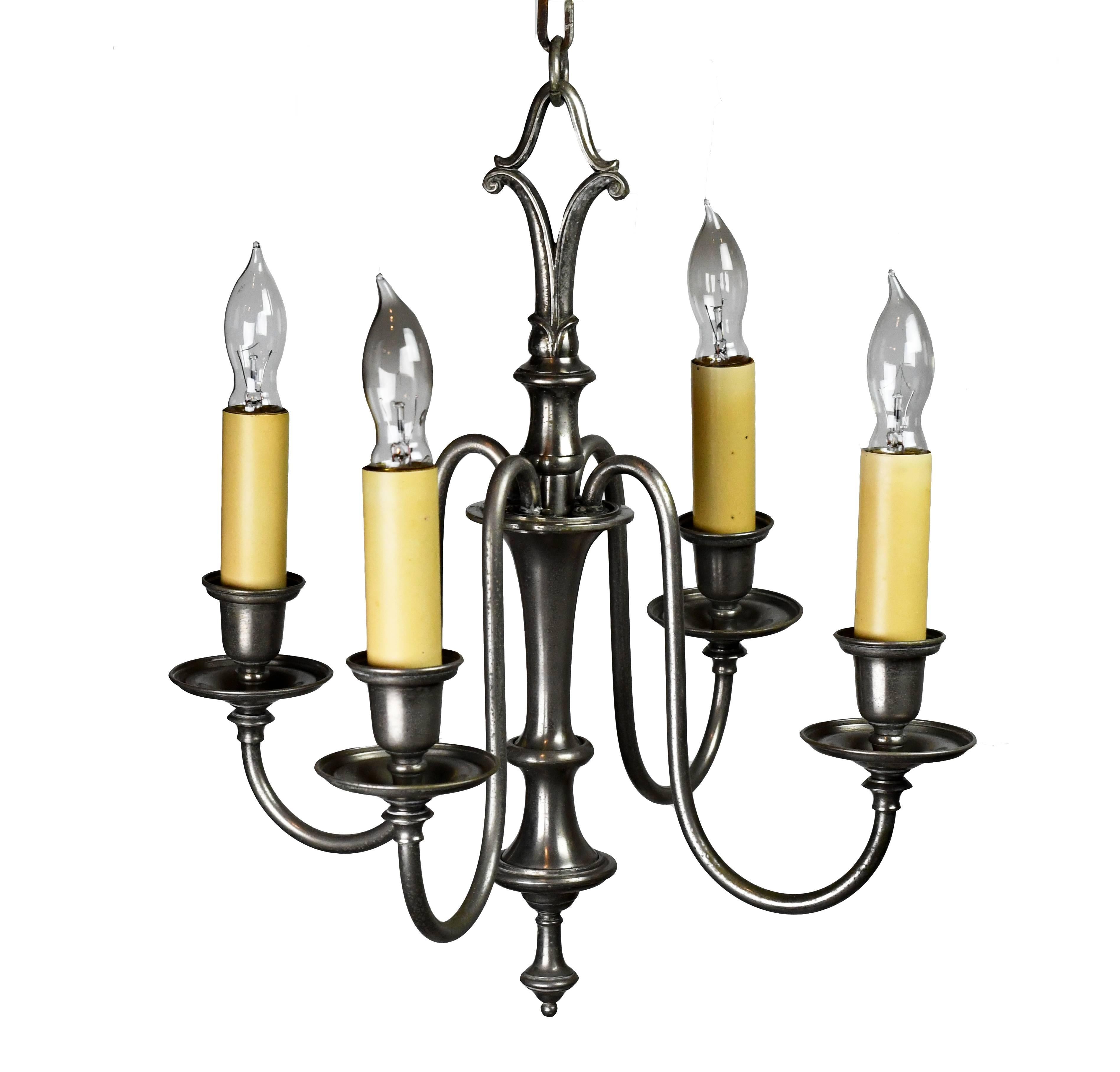 This Bradley & Hubbard silver plated four-arm sconce is simple in design, with four thin, curving arms, simple bottom finial, and subtly decorative chain loop. This chandelier's beautiful form and elegant, lovely design would make it the perfect