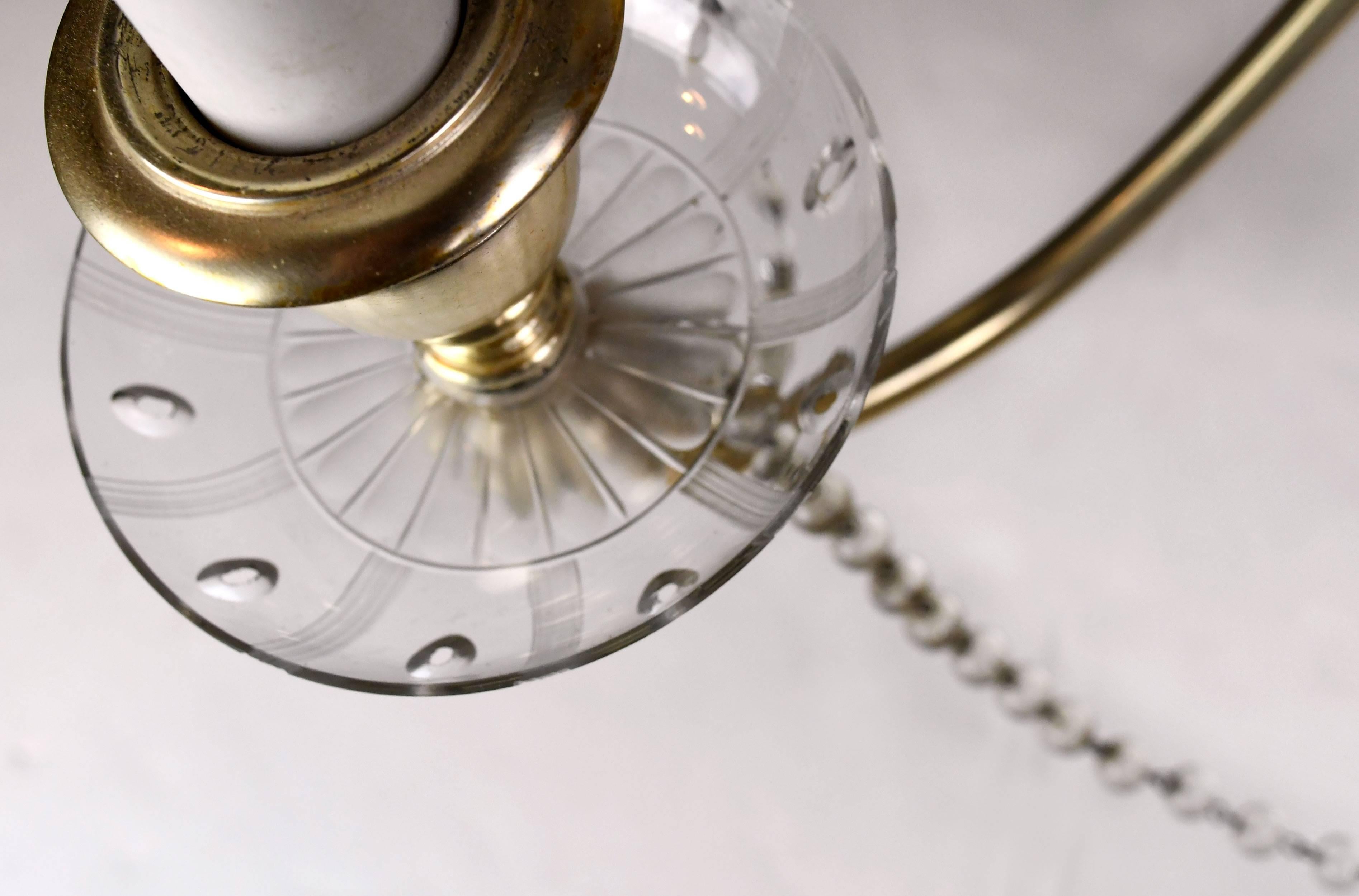 This exquisite, silver plated six-arm chandelier features original porcelain candle covers, two tiers of teardrop crystals, decorative glass bobeches and beaded crystal roping that winds delicately from one arm to the next. This fixture was made by