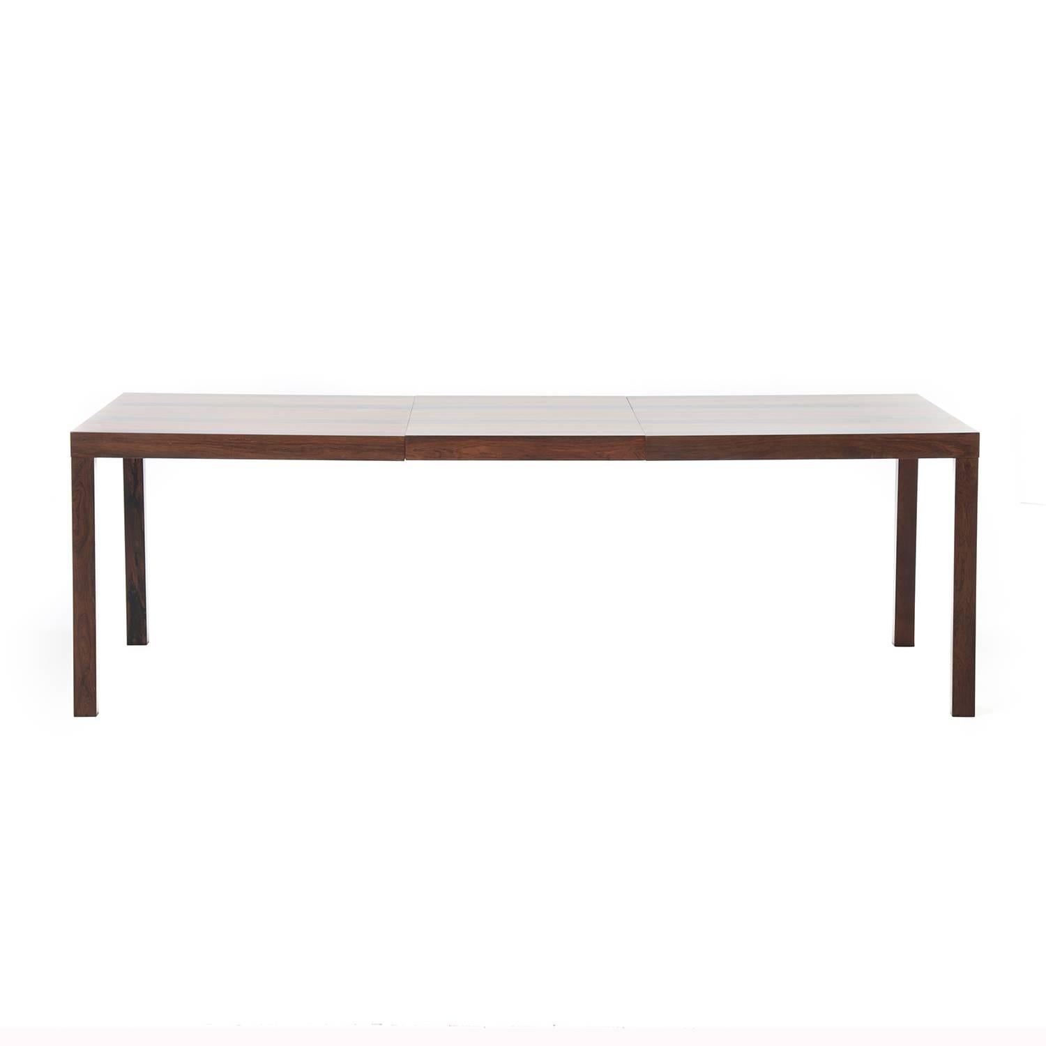 This beautiful butcher block dining table is constructed of teak and rosewood, and it comes with one extension leaf that extends the table to 88.5