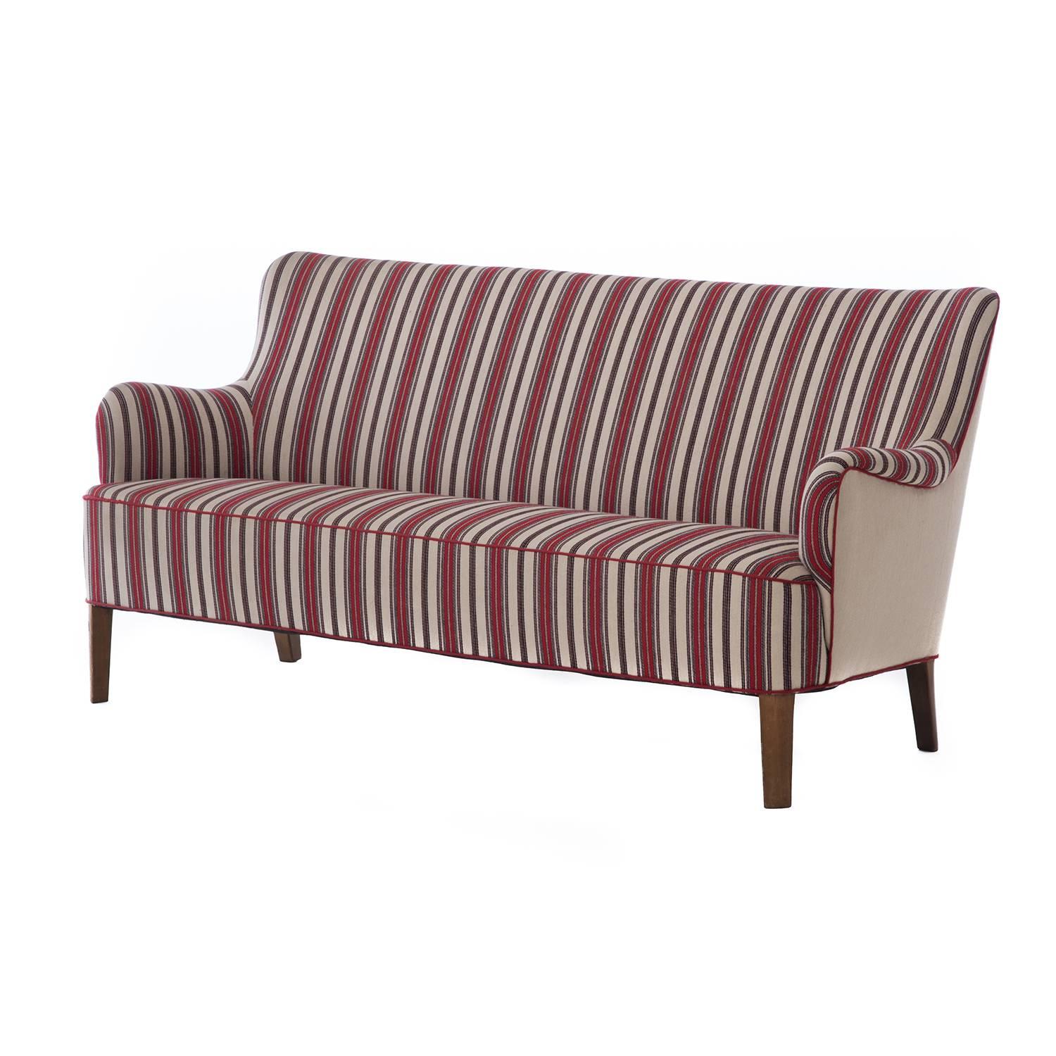 This lovely Danish modern settee is a Classic example of refined early 20th century Scandinavia from the 1930s. It retains its high quality wool upholstery in excellent condition. Note that the back is upholstered in a solid wool at one point in