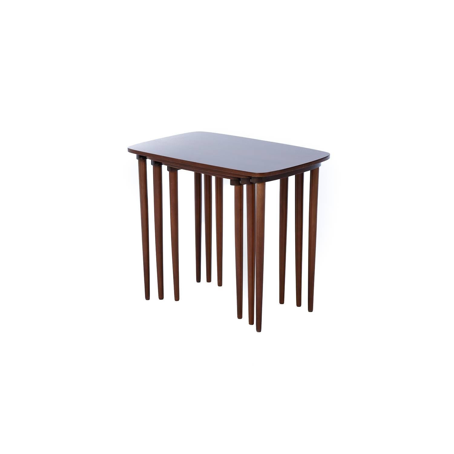 Matchstick legs give these mahogany nesting tables a slender appearance. These are original tables from 1940s, Denmark. Lines are traditional with a modernist flare. When stacked the interior tables legs float just above the ground.